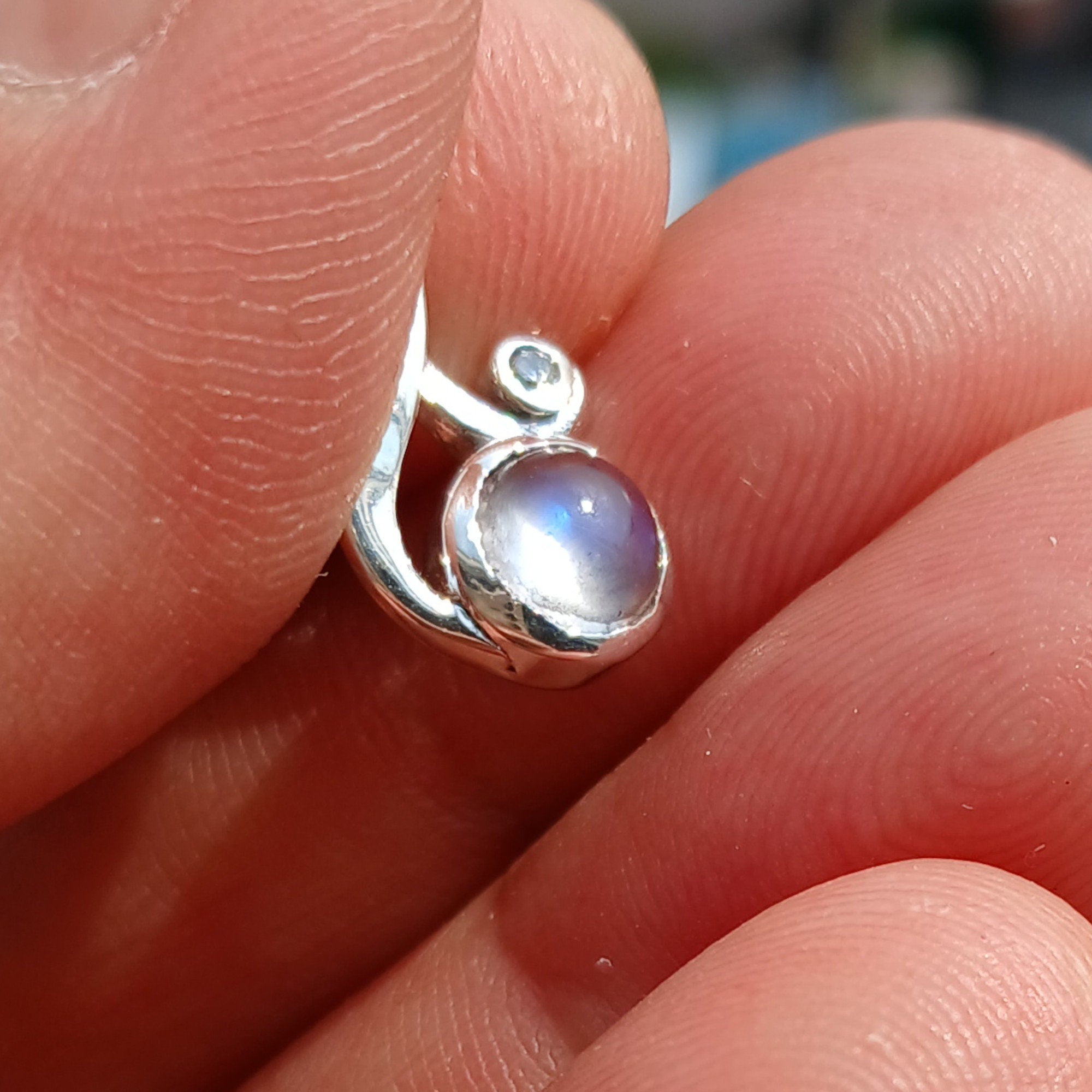 A beautiful sterling silver moonstone pendant featuring cubic zirconias, showcasing its elegant design and dimensions.