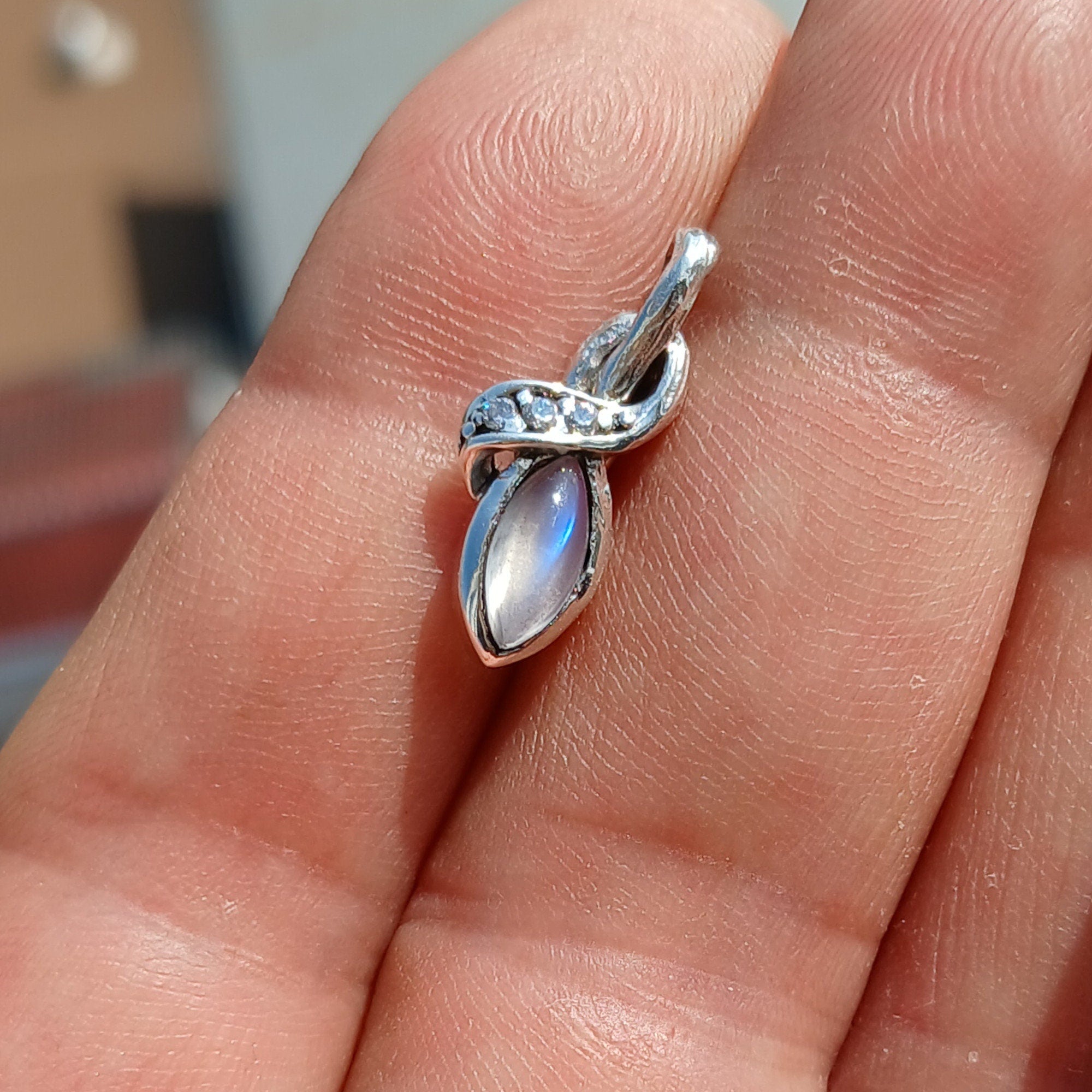 Elegant Moonstone Pendant in sterling silver with cubic zirconias, showcasing its natural beauty and craftsmanship.