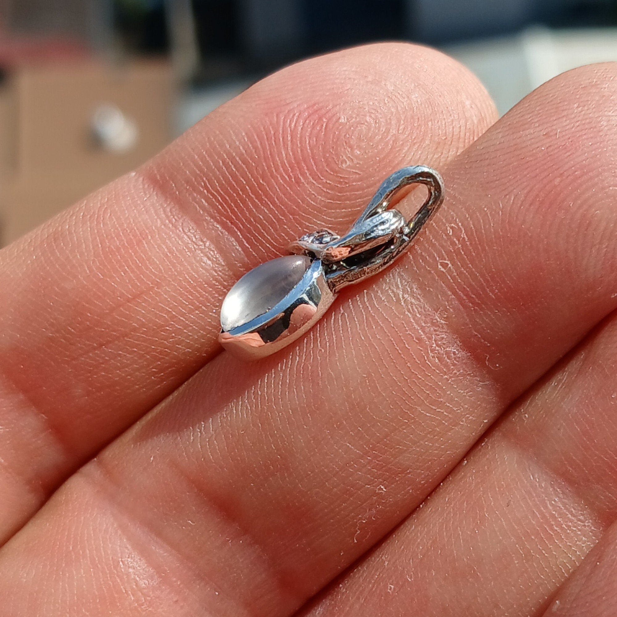 Elegant Moonstone Pendant in sterling silver with cubic zirconias, showcasing its natural beauty and craftsmanship.