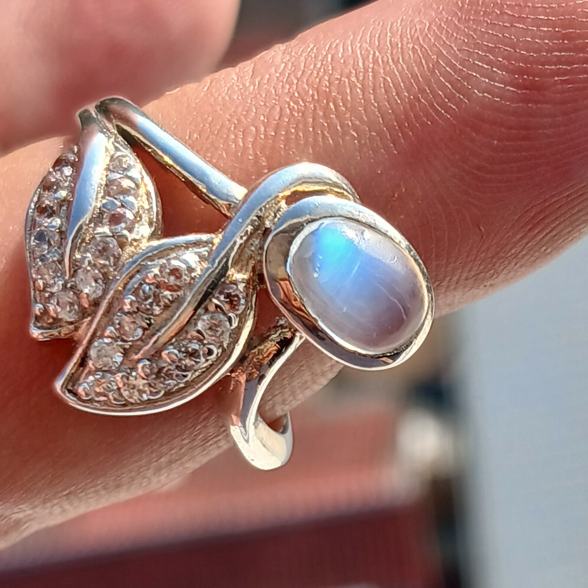 A polished sterling silver ring featuring an oval moonstone, showcasing its unique sheen and elegant design.