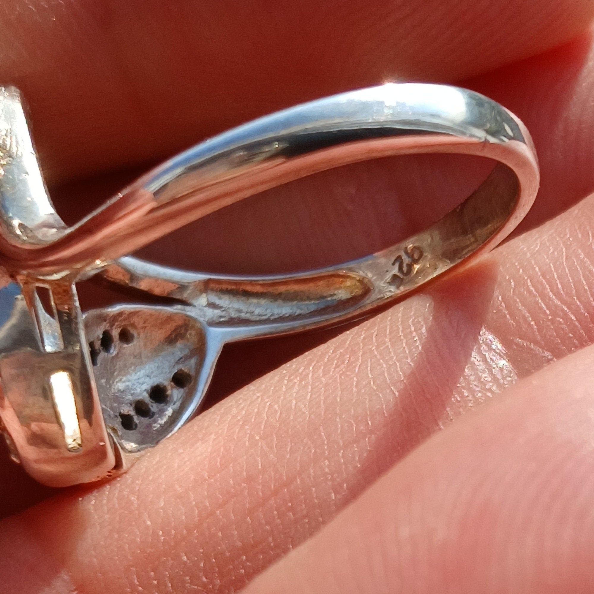 A polished sterling silver ring featuring an oval moonstone, showcasing its unique sheen and elegant design.