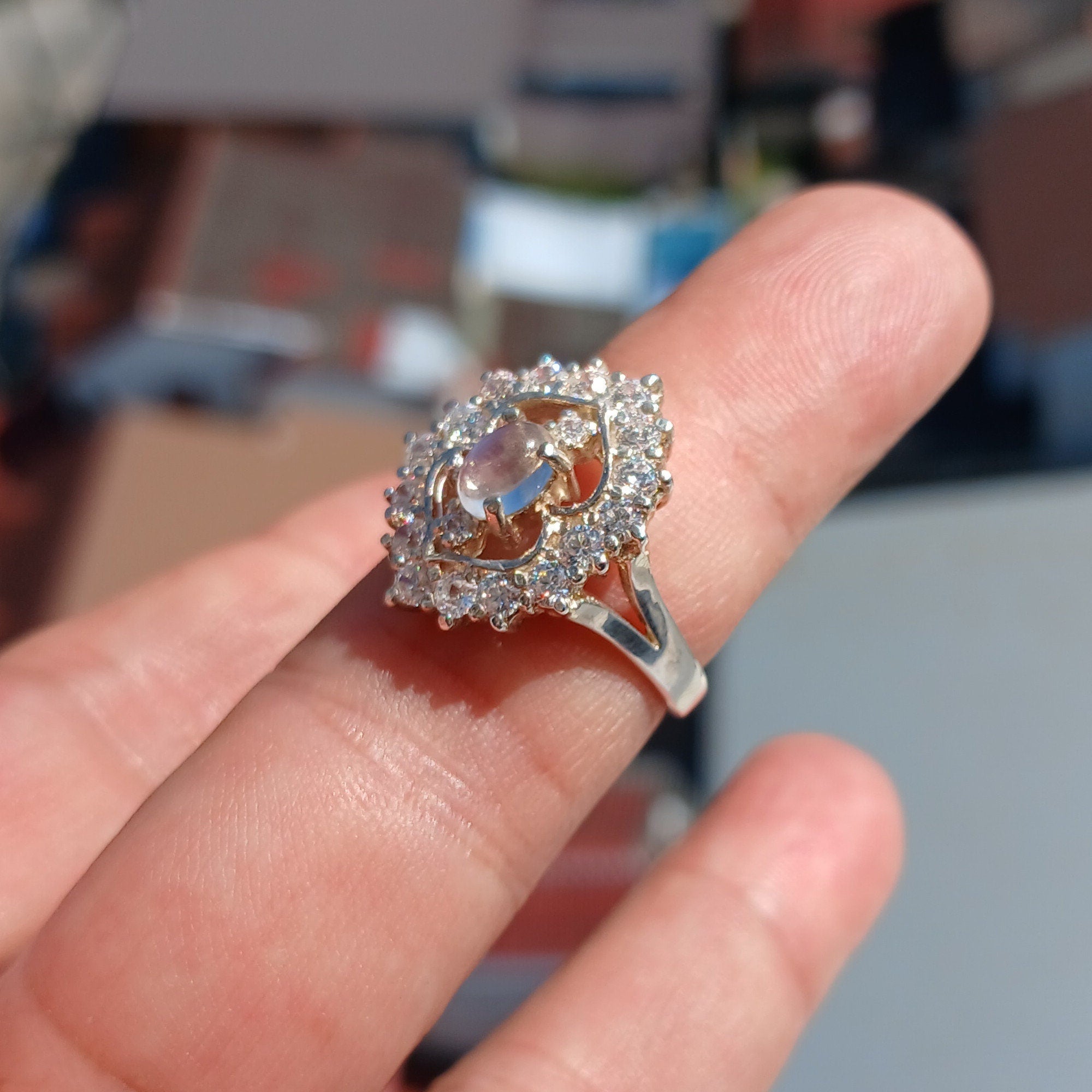 A polished sterling silver ring featuring an oval moonstone, showcasing its elegant design and hallmarked 925 authenticity.