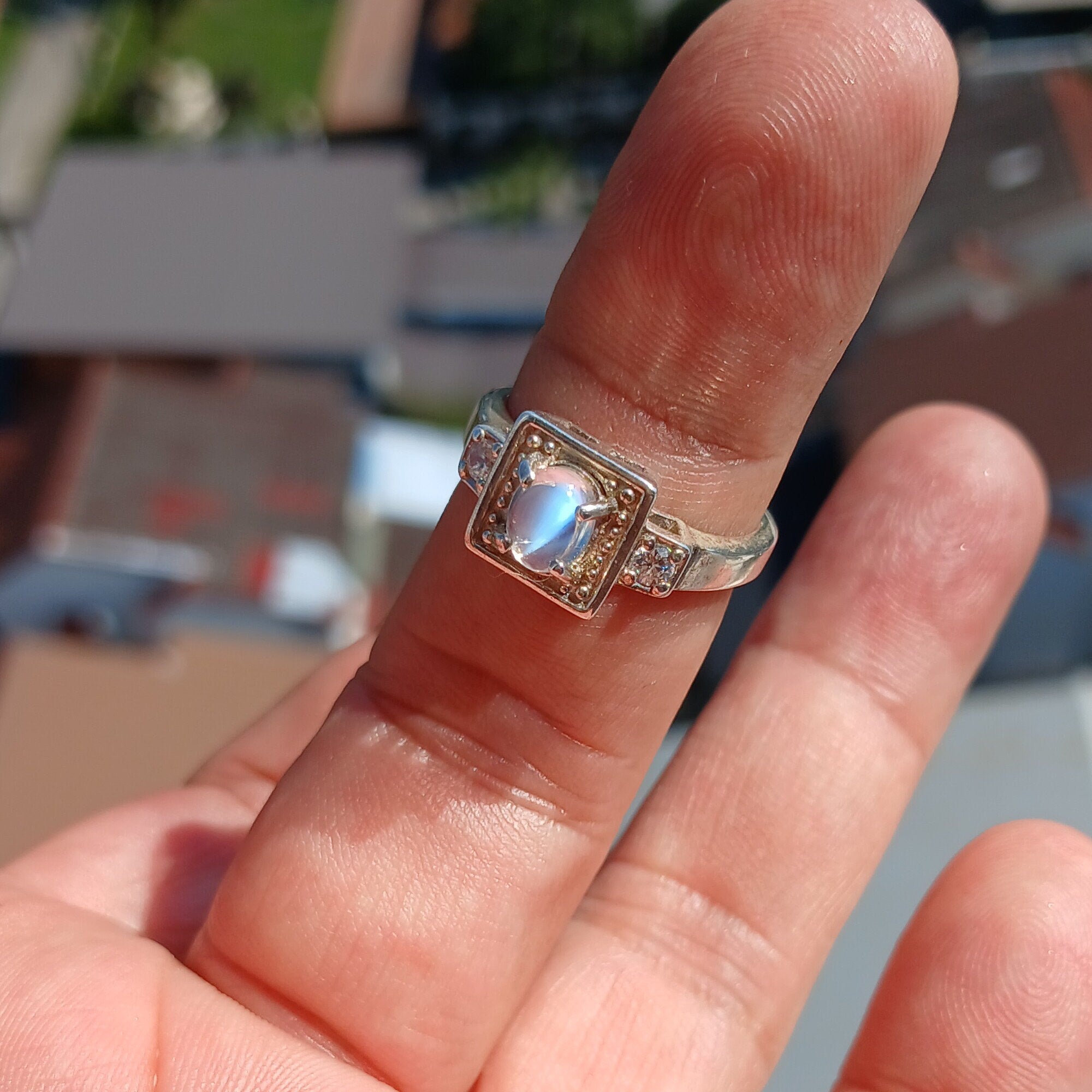 A beautifully polished sterling silver ring featuring an oval moonstone, showcasing a square-shaped design and hallmarked 925.