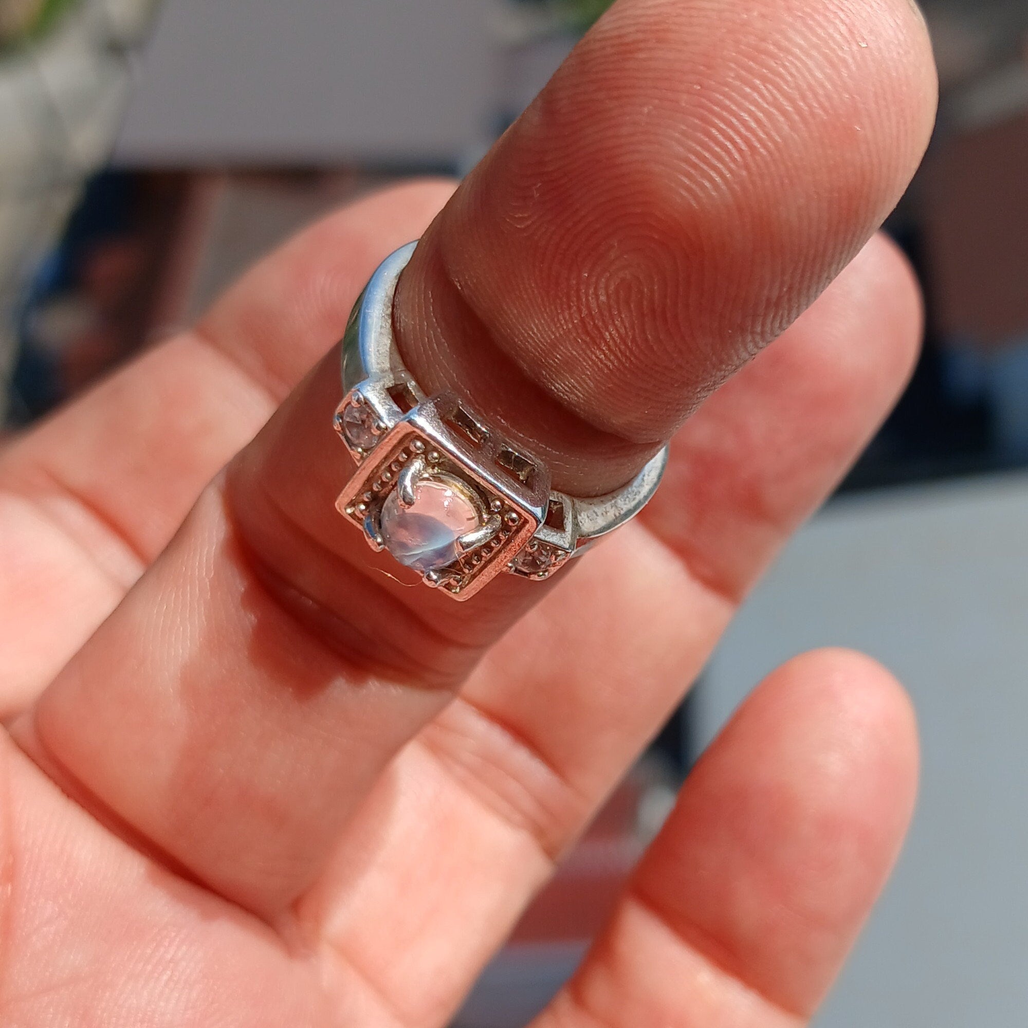 A beautifully polished sterling silver ring featuring an oval moonstone, showcasing a square-shaped design and hallmarked 925.