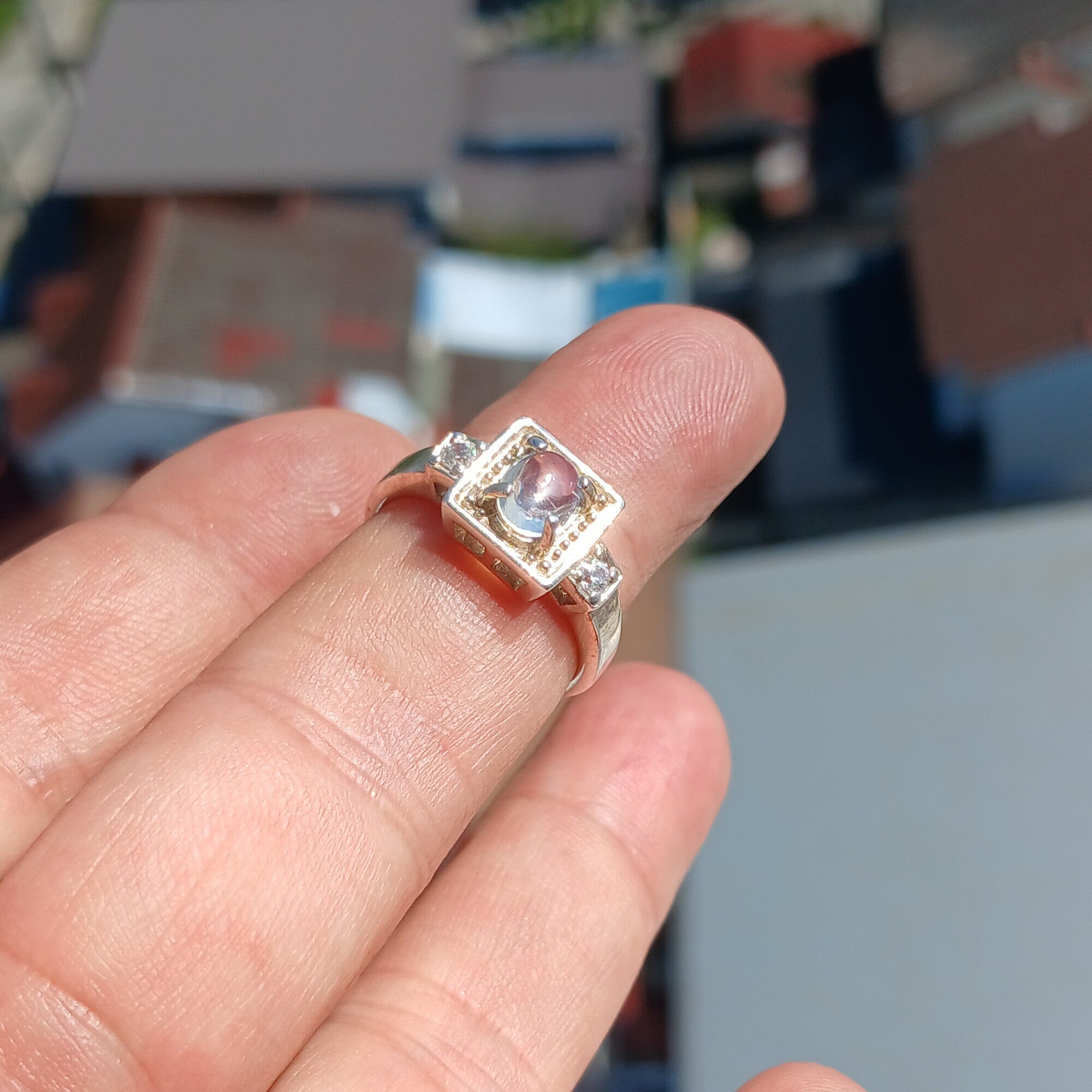 A beautifully polished sterling silver ring featuring an oval moonstone, showcasing a square-shaped design and hallmarked 925.