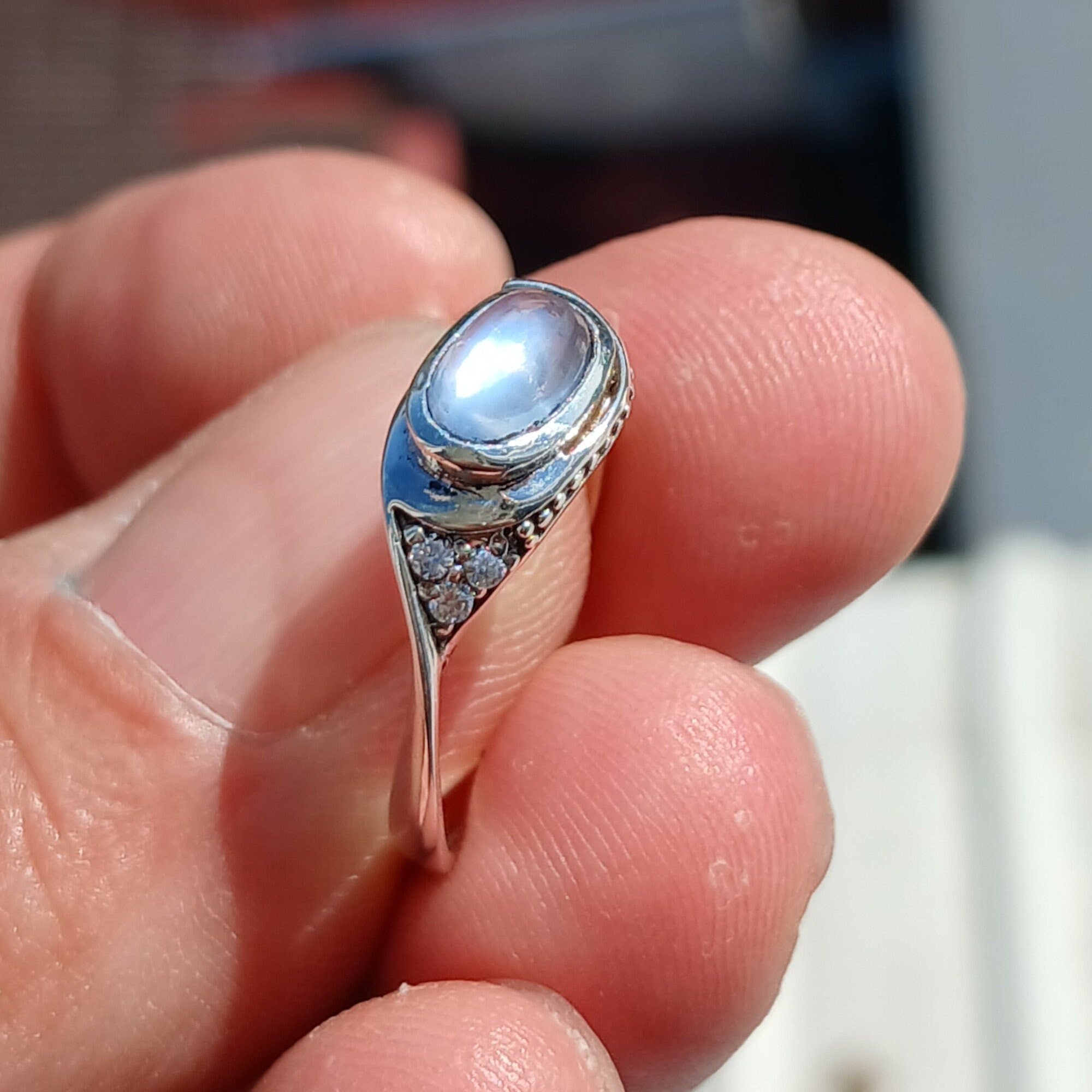 Elegant Moonstone Ring featuring a natural oval Ceylon Moonstone set in sterling silver with four cubic zirconia accents.