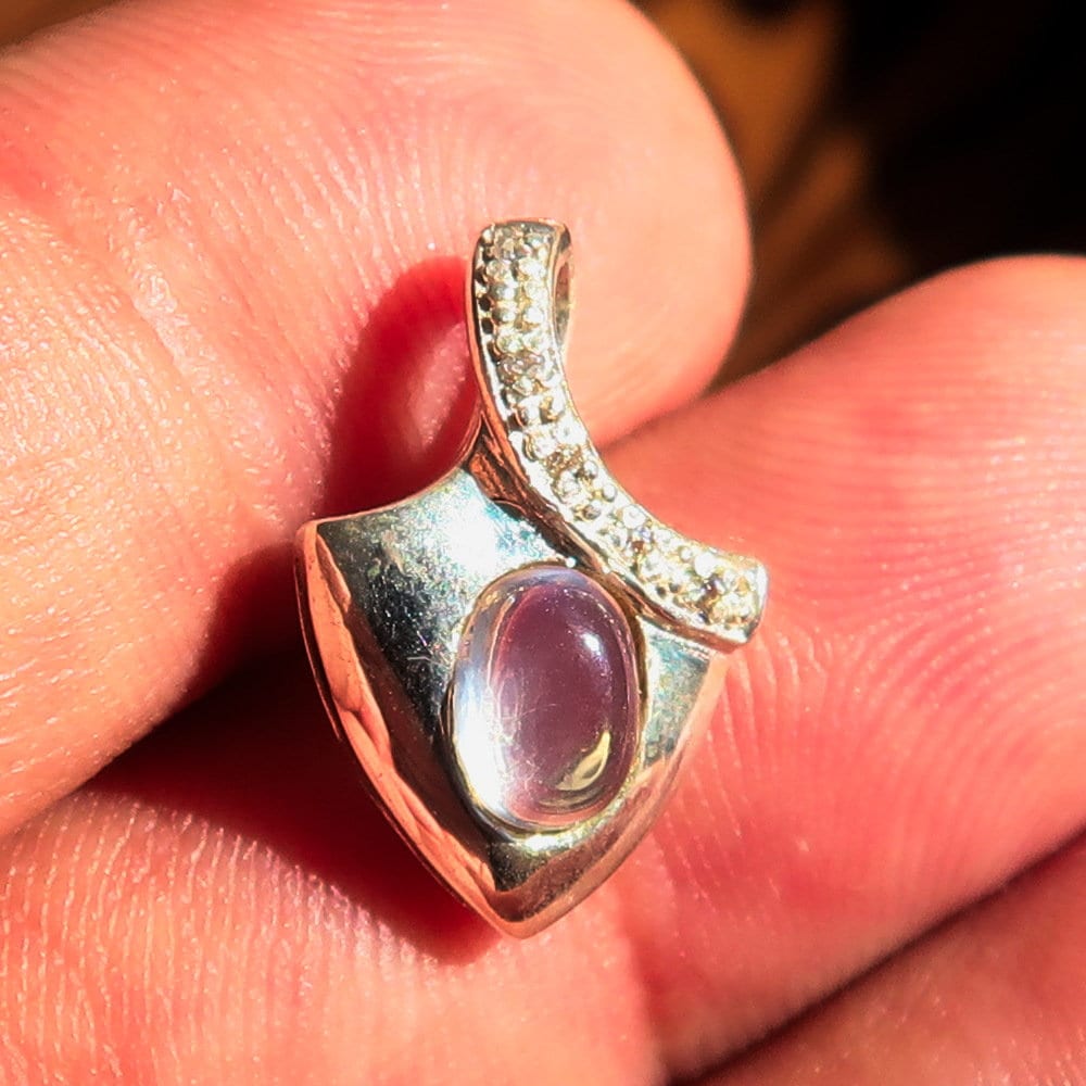 A stunning Moonstone Silver Pendant featuring an oval Ceylon Moonstone surrounded by sparkling Cubic Zirconias, crafted from high-quality sterling silver.