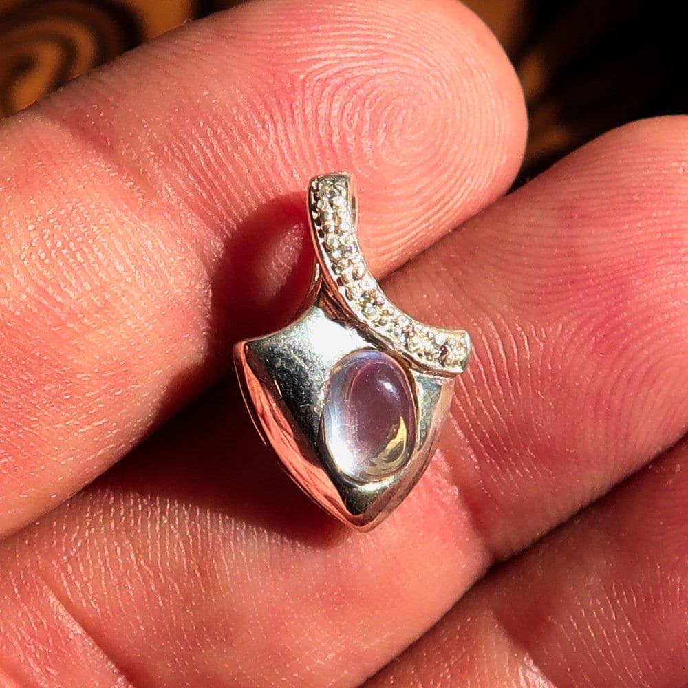 A stunning Moonstone Silver Pendant featuring an oval Ceylon Moonstone surrounded by sparkling Cubic Zirconias, crafted from high-quality sterling silver.