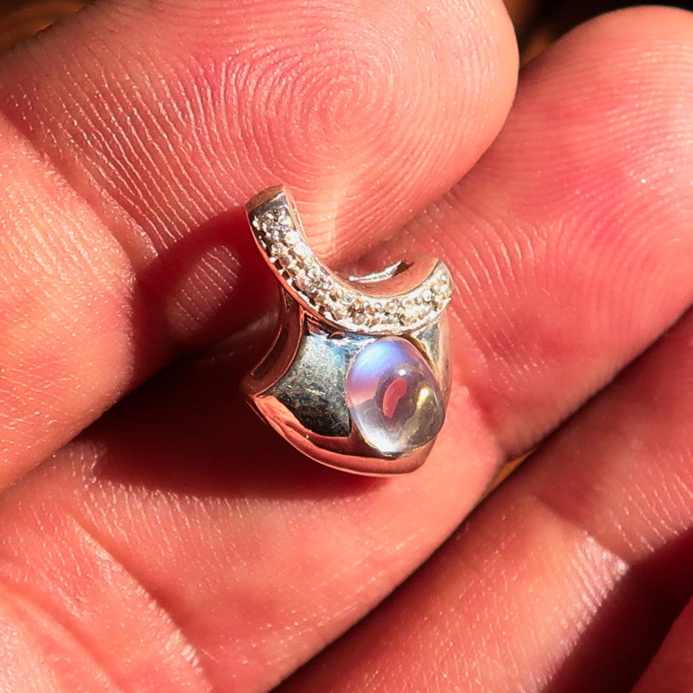 A stunning Moonstone Silver Pendant featuring an oval Ceylon Moonstone surrounded by sparkling Cubic Zirconias, crafted from high-quality sterling silver.