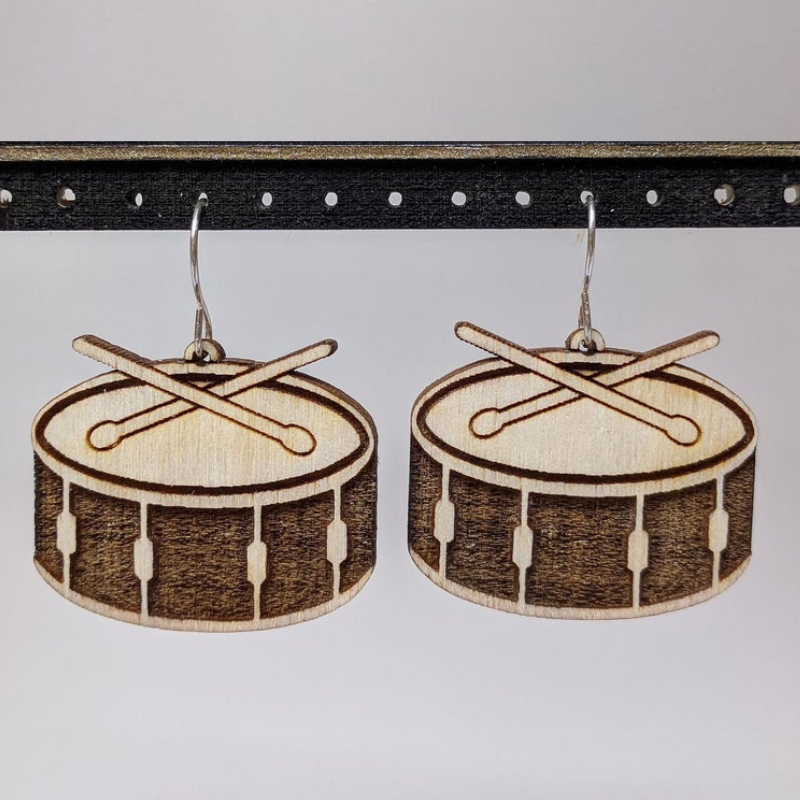 A pair of Musical Instruments Natural Wood Earrings featuring miniature wooden instruments like guitars and drums, crafted from lightweight Birchwood.