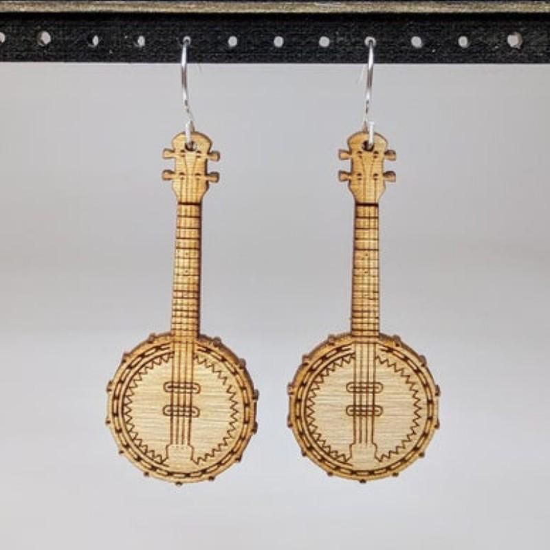 A pair of Musical Instruments Natural Wood Earrings featuring miniature wooden instruments like guitars and drums, crafted from lightweight Birchwood.