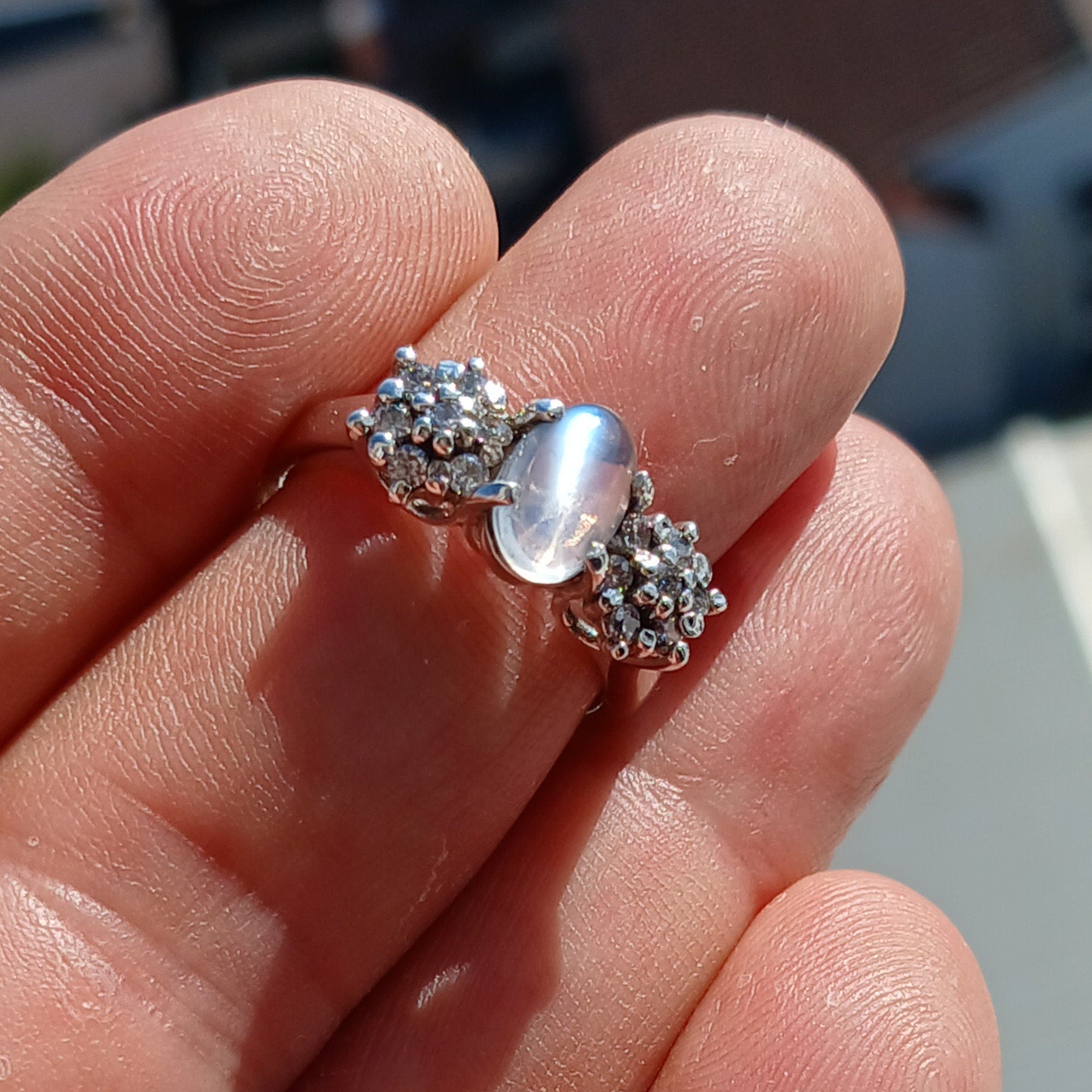 A beautiful handmade Natural Moonstone Ring featuring an oval Ceylon Moonstone surrounded by 14 sparkling CZ stones in a polished sterling silver band.
