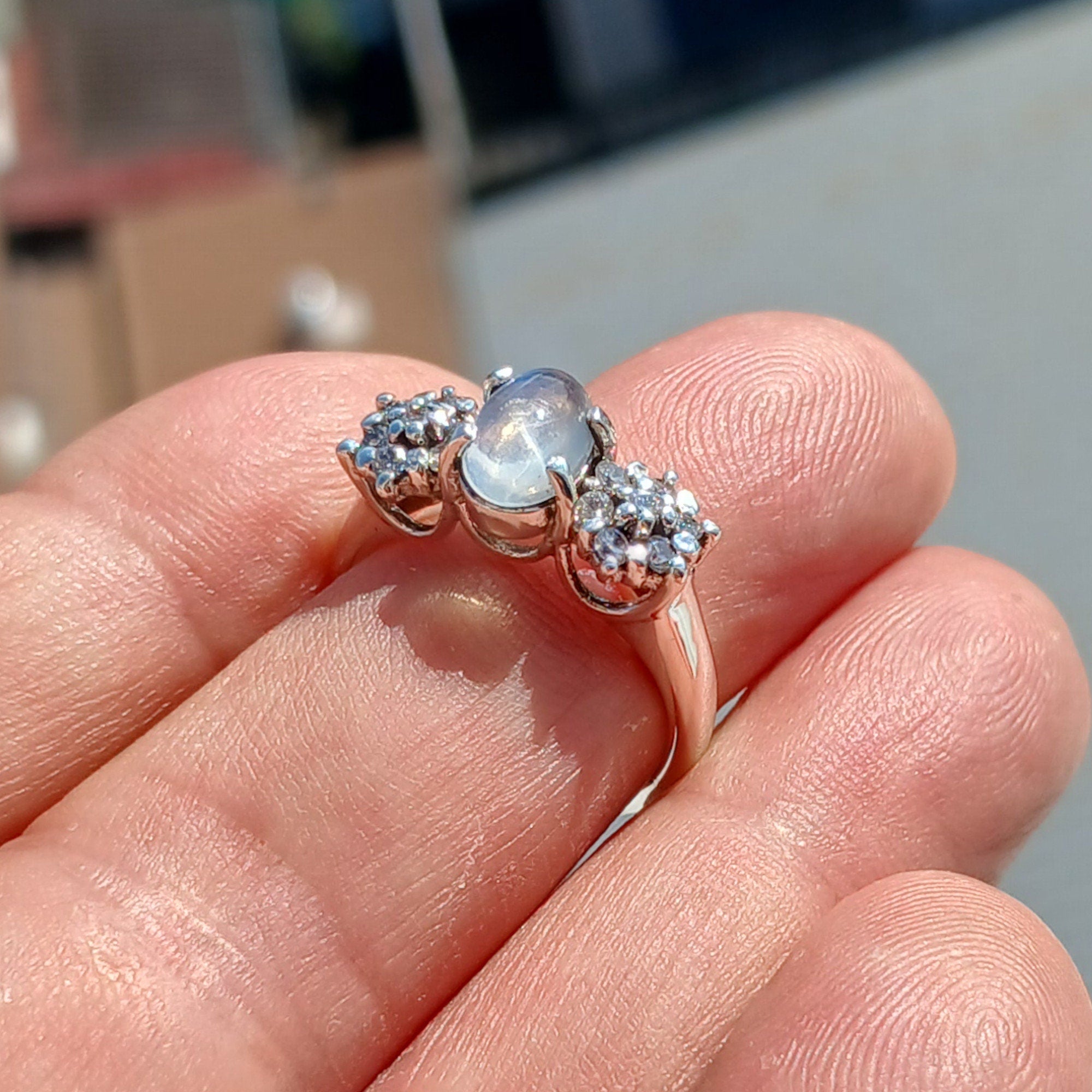 A beautiful handmade Natural Moonstone Ring featuring an oval Ceylon Moonstone surrounded by 14 sparkling CZ stones in a polished sterling silver band.