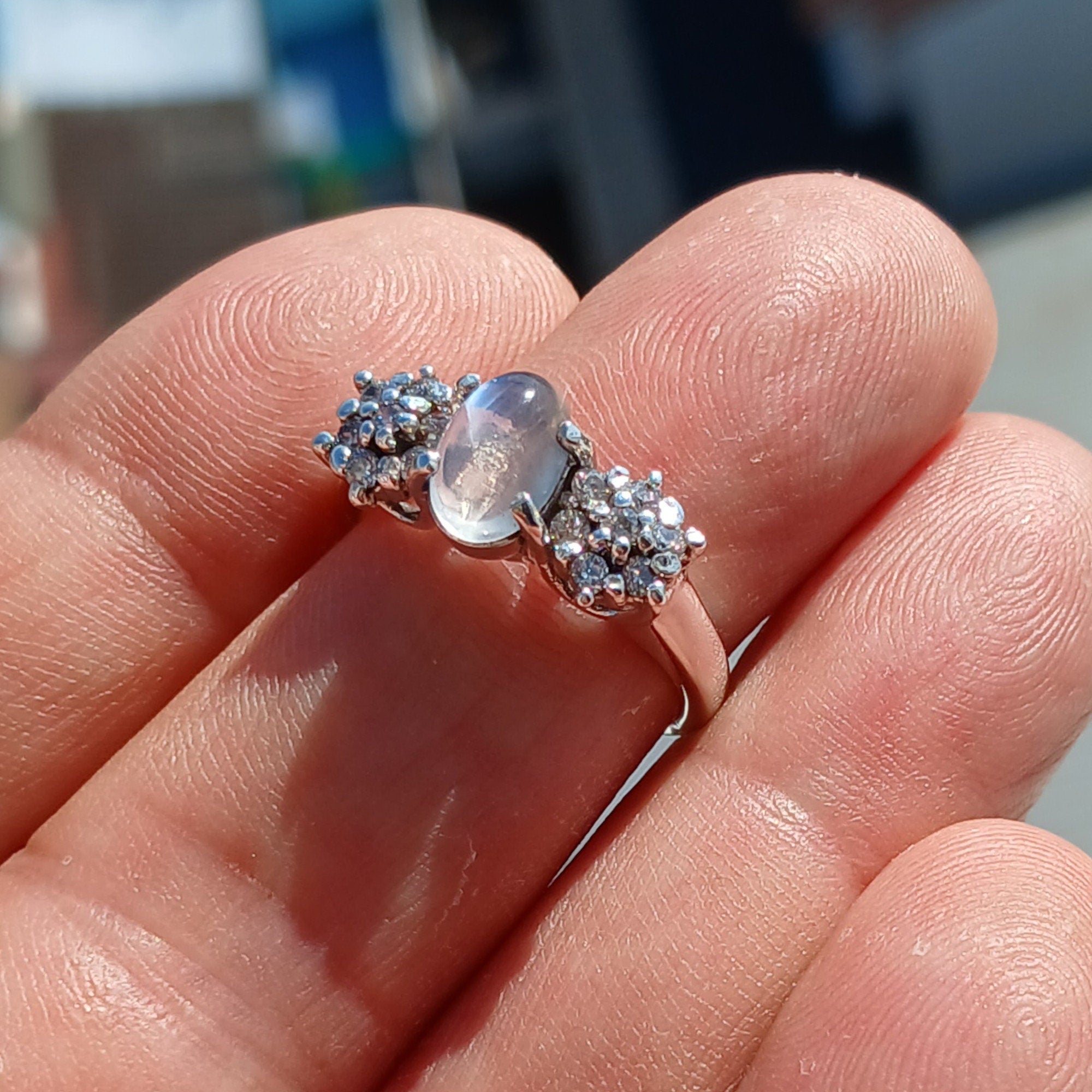 A beautiful handmade Natural Moonstone Ring featuring an oval Ceylon Moonstone surrounded by 14 sparkling CZ stones in a polished sterling silver band.