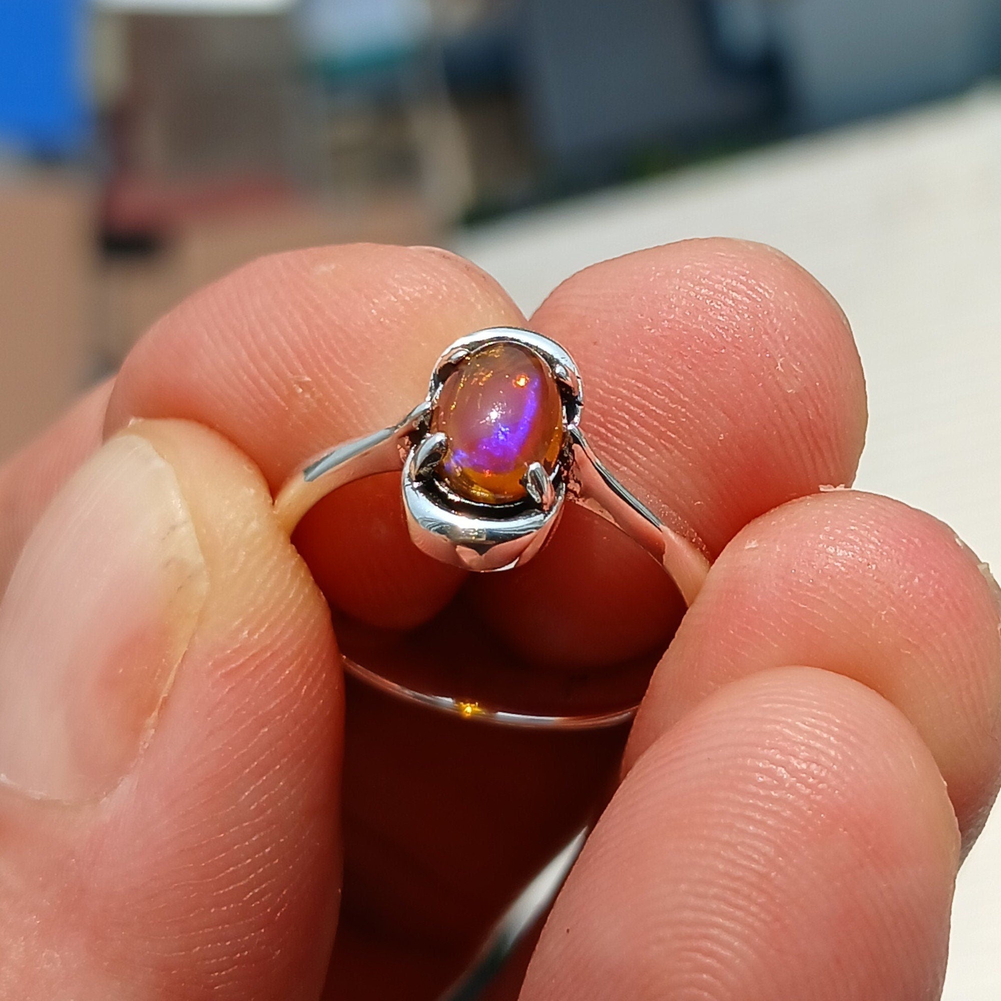 A beautiful Natural Opal Ring featuring an oval-shaped opal set in a polished sterling silver band, showcasing vibrant colors and elegant design.