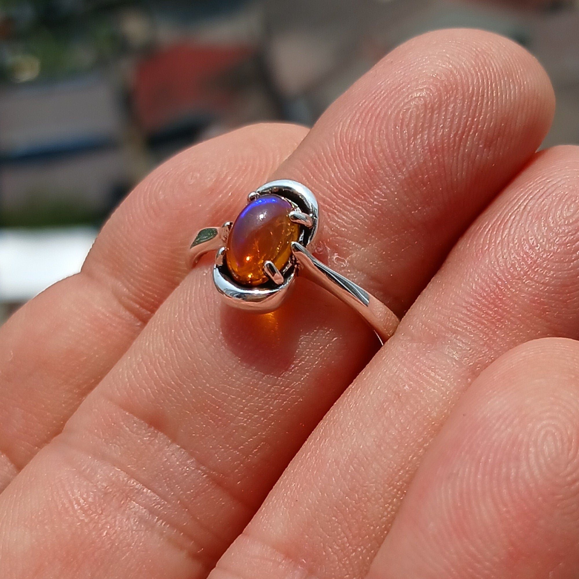 A beautiful Natural Opal Ring featuring an oval-shaped opal set in a polished sterling silver band, showcasing vibrant colors and elegant design.