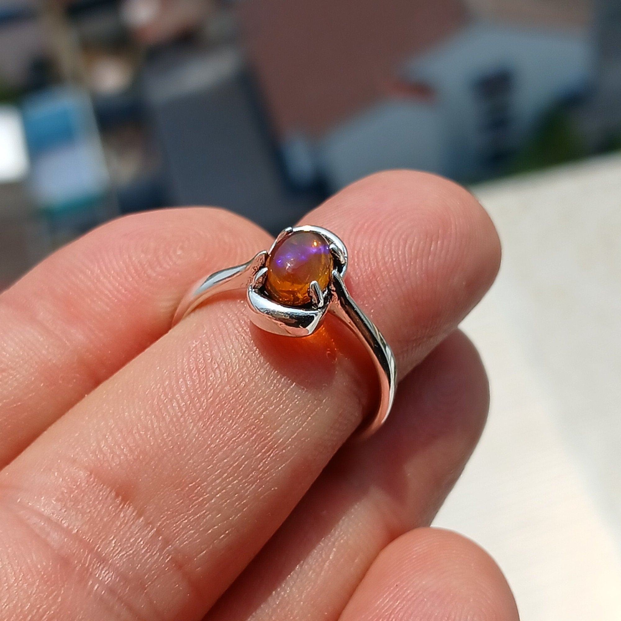 A beautiful Natural Opal Ring featuring an oval-shaped opal set in a polished sterling silver band, showcasing vibrant colors and elegant design.