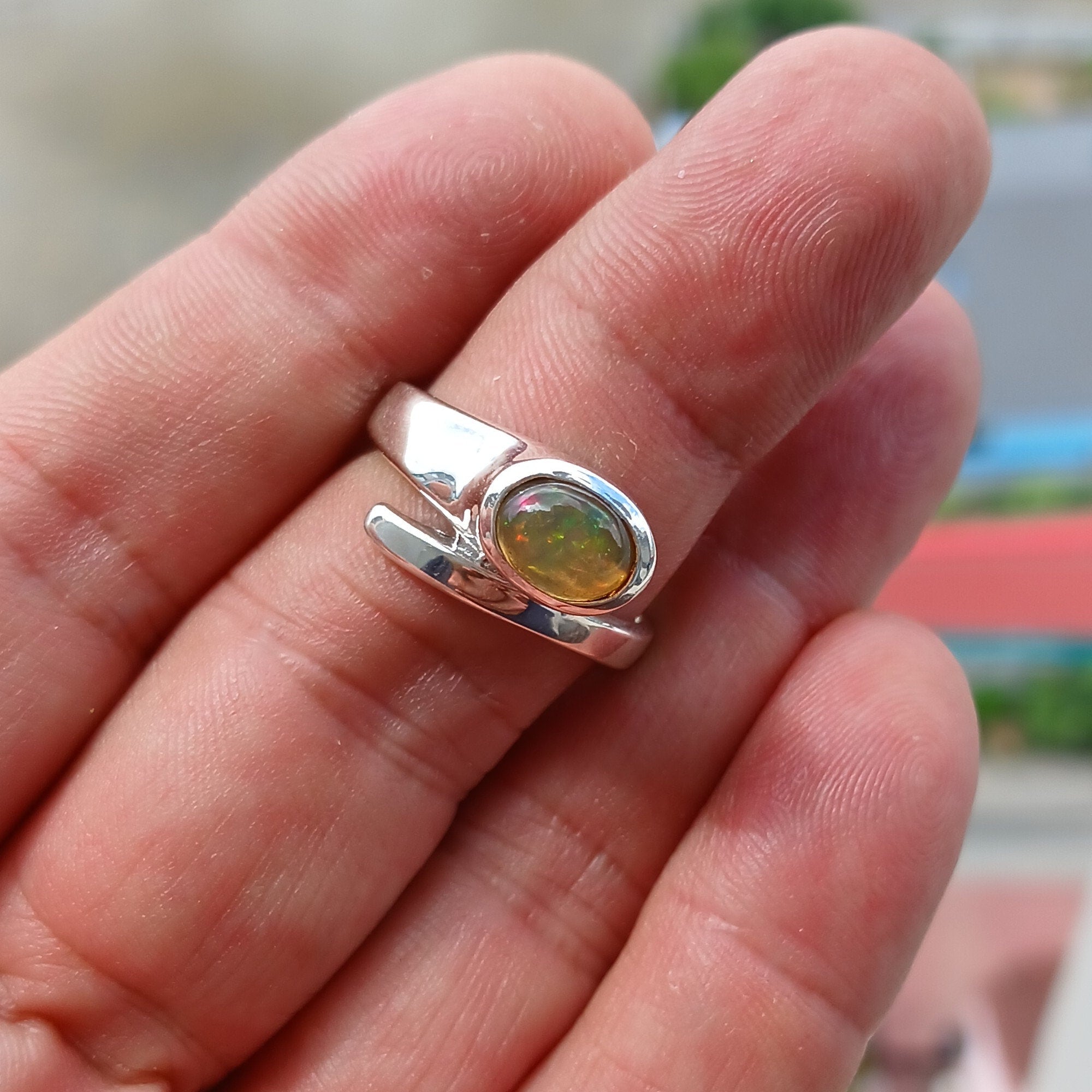 Natural Opal Ring in sterling silver featuring an oval-shaped opal with vibrant colors and a mirror polished finish.