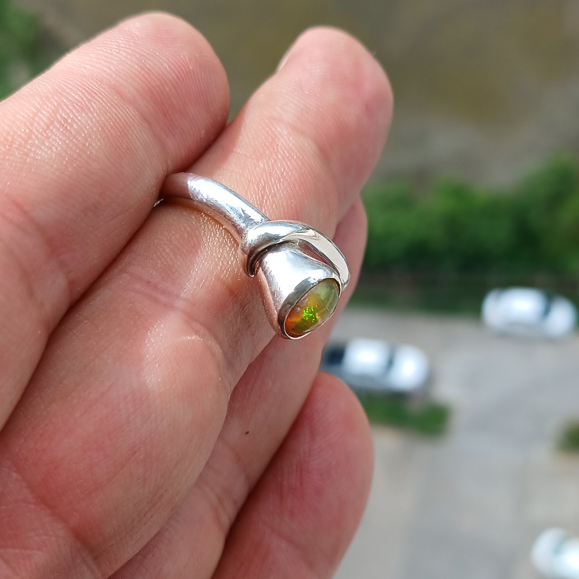 A beautifully handcrafted sterling silver Opal Ring featuring an oval-shaped opal with vibrant colors, set in a minimalist design.