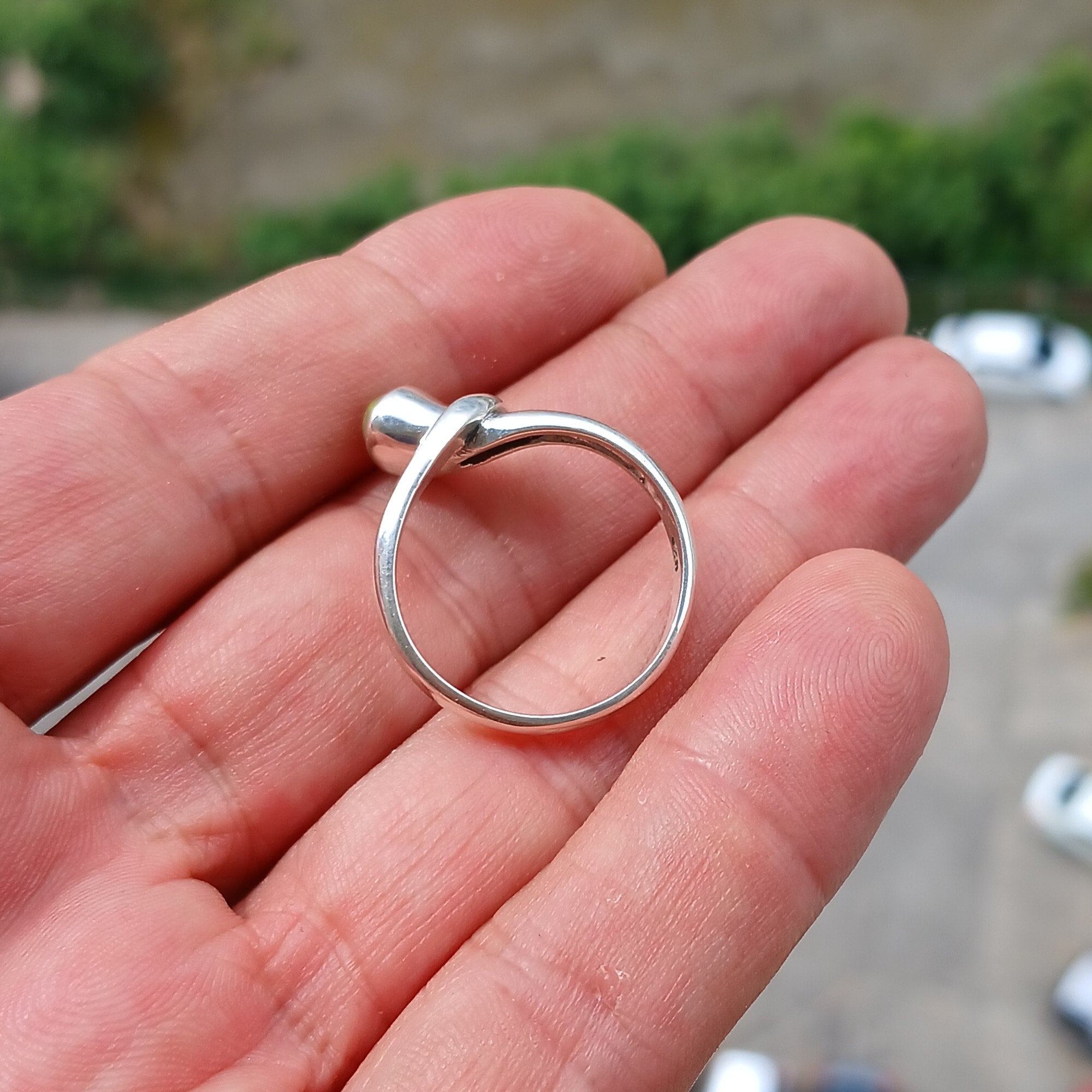 A beautifully handcrafted sterling silver Opal Ring featuring an oval-shaped opal with vibrant colors, set in a minimalist design.