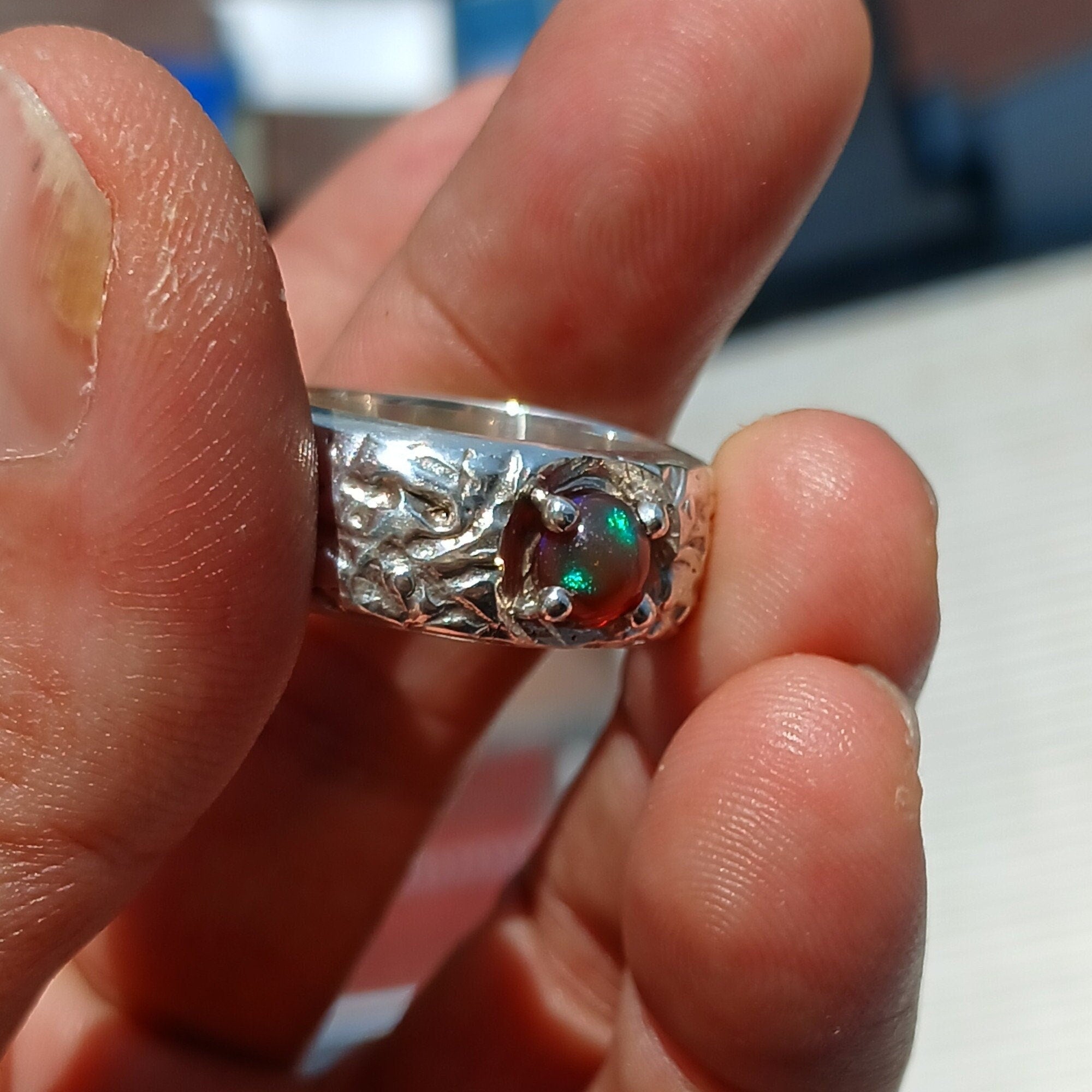 A stunning Opal Silver Ring featuring a round multi-color Opal set in a polished sterling silver band, showcasing elegance and craftsmanship.