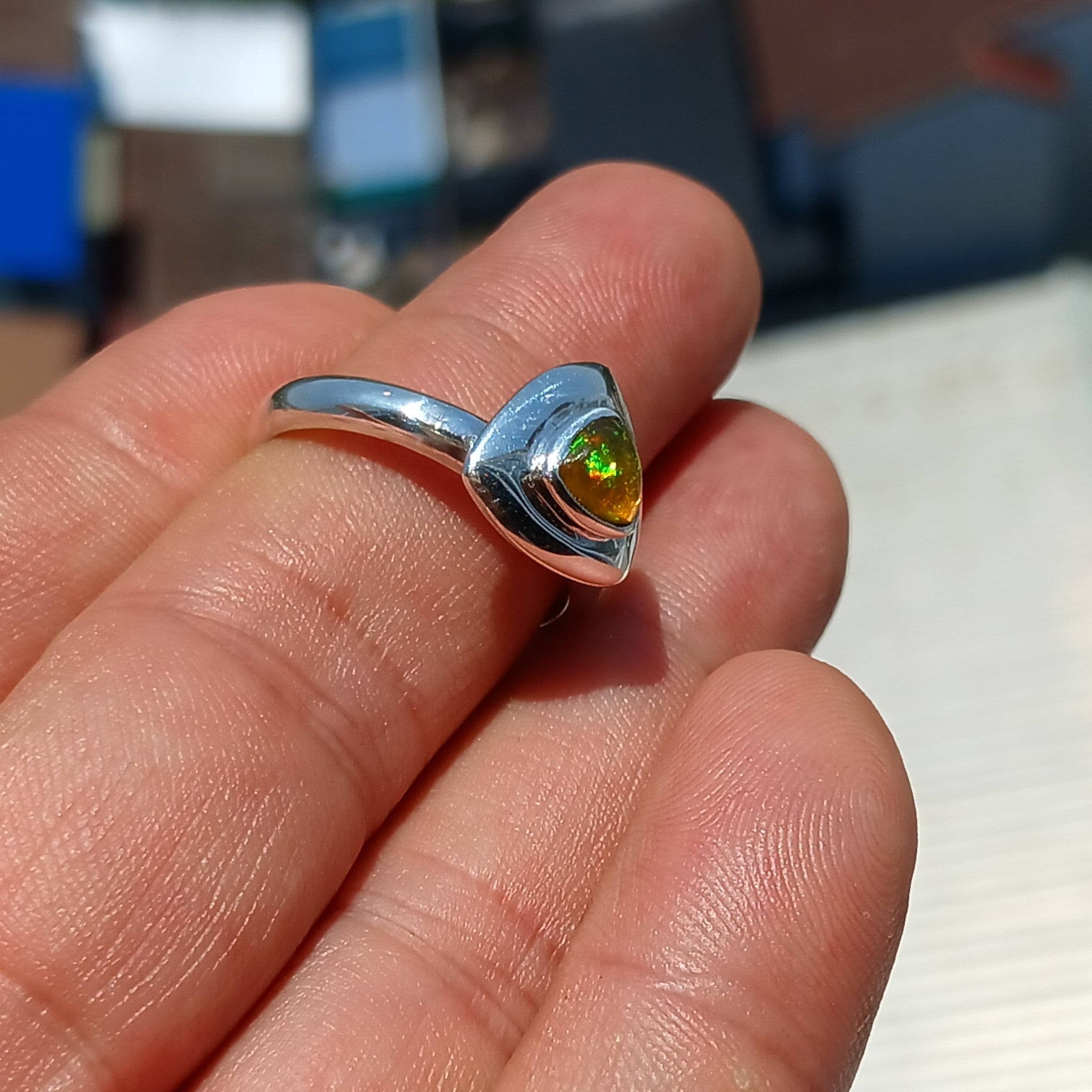 A stunning triangle-shaped Opal Ring set in high-quality sterling silver, showcasing a vibrant play of colors.