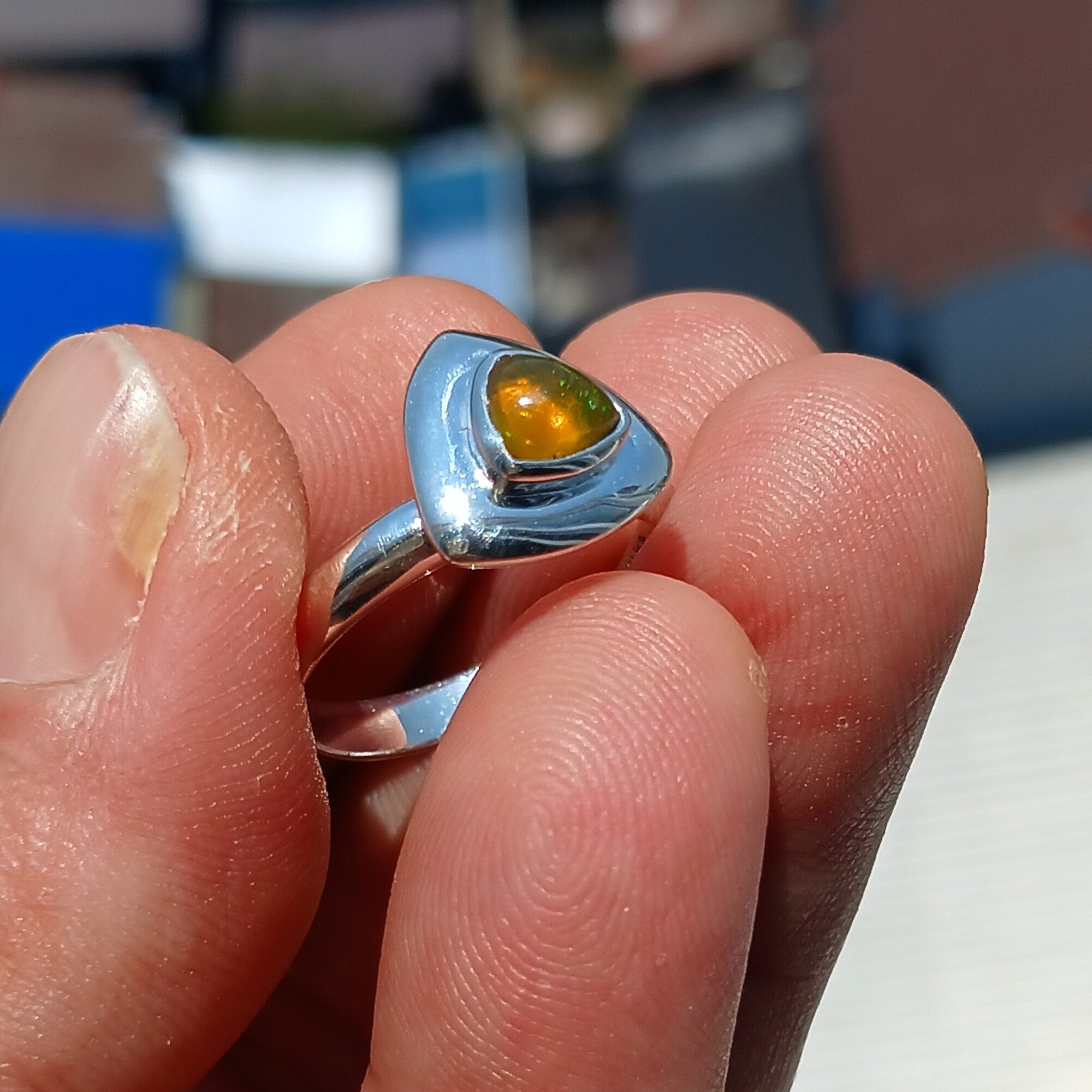 A stunning triangle-shaped Opal Ring set in high-quality sterling silver, showcasing a vibrant play of colors.