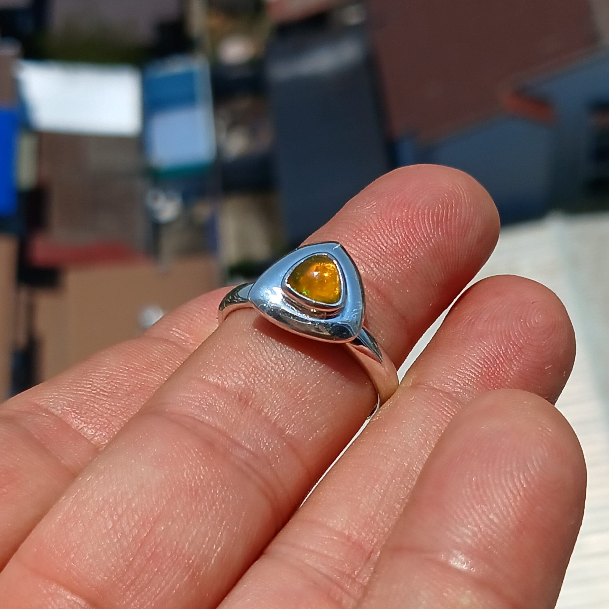 A stunning triangle-shaped Opal Ring set in high-quality sterling silver, showcasing a vibrant play of colors.