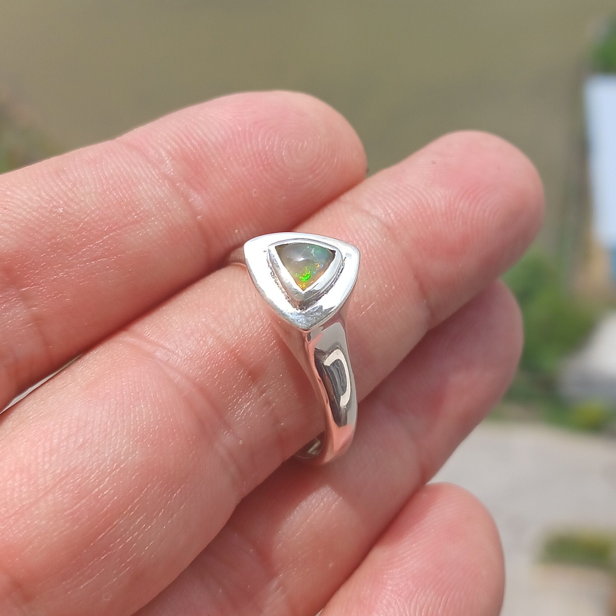 A stunning triangle-shaped Opal Ring made of high-quality sterling silver, showcasing a vibrant play of colors.