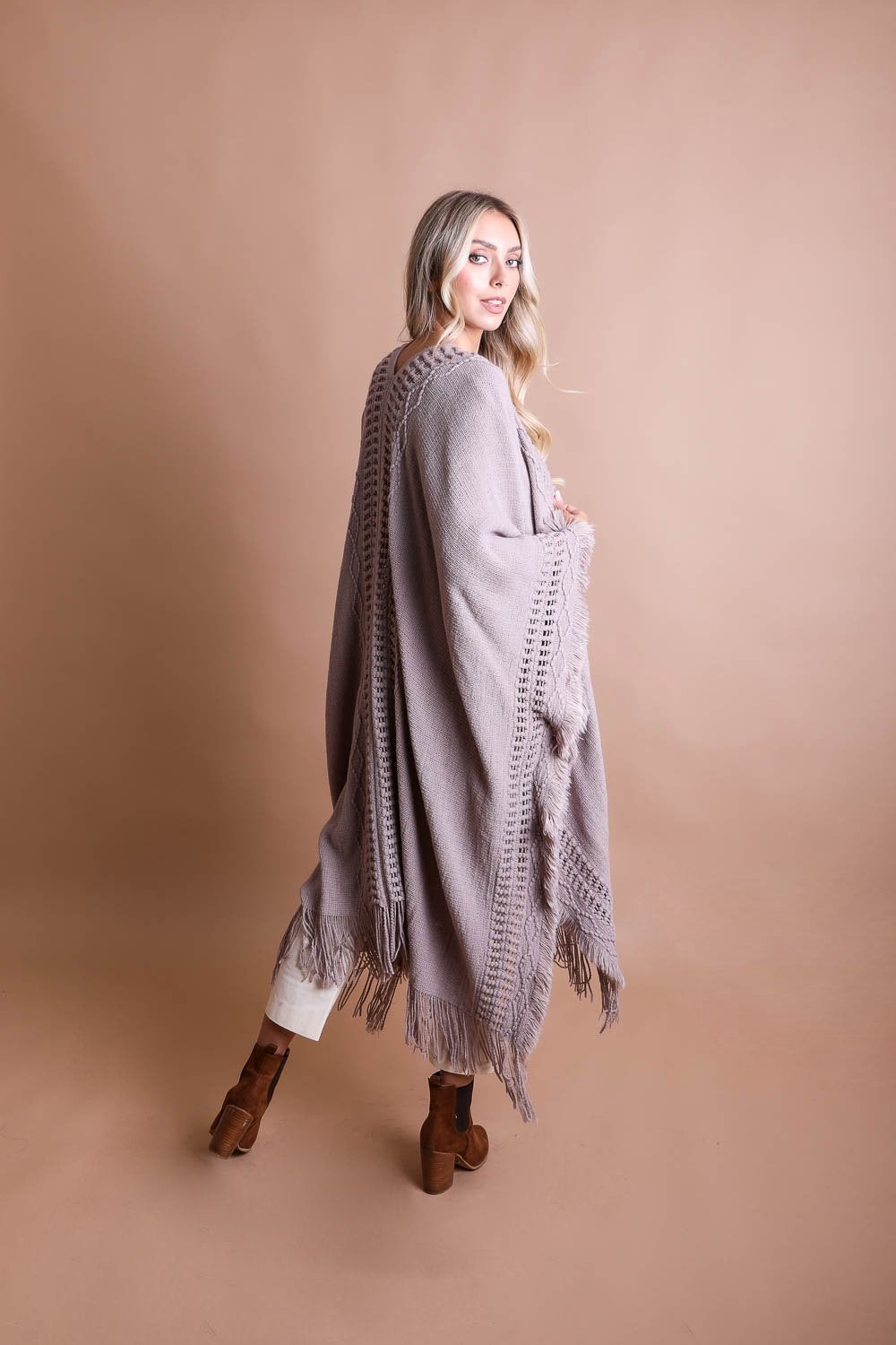 Open Work Frayed Bohemian Ruana showcasing a stylish knitted design with frayed edges, perfect for layering.