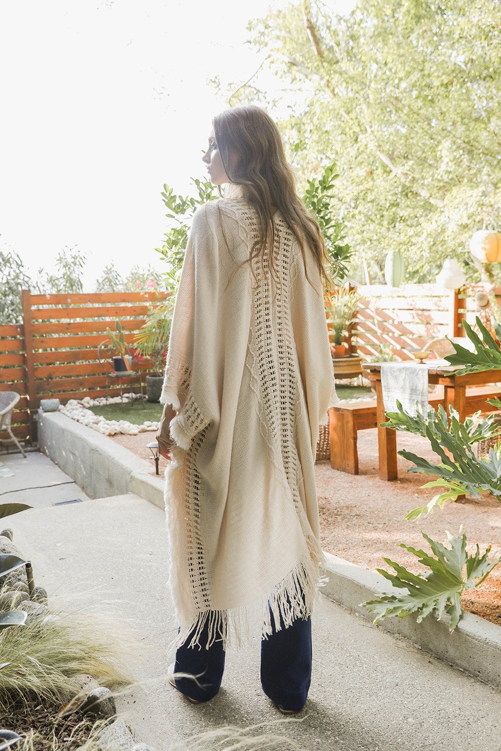 Open Work Frayed Bohemian Ruana showcasing a stylish knitted design with frayed edges, perfect for layering.