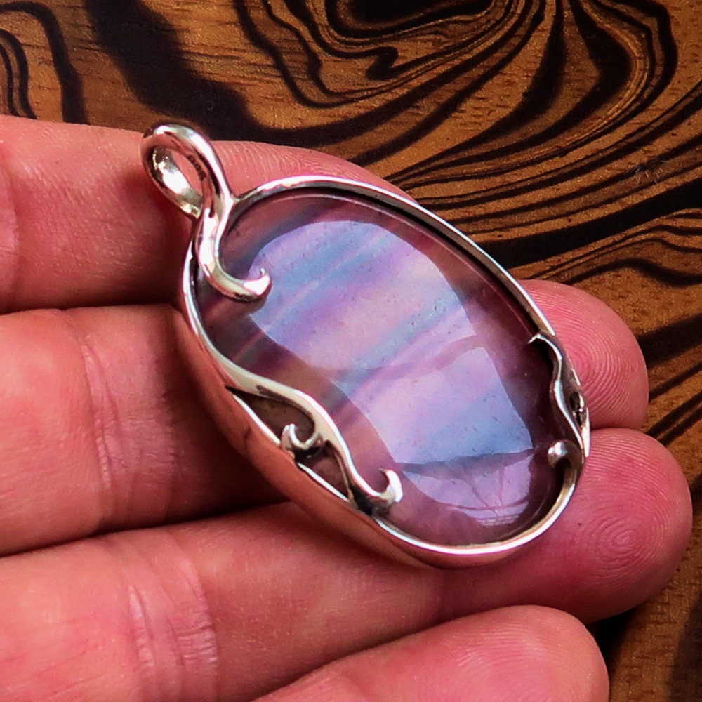 Oval shaped sterling silver pendant featuring a multicolor fluorite gemstone, elegantly designed with a pear cut.