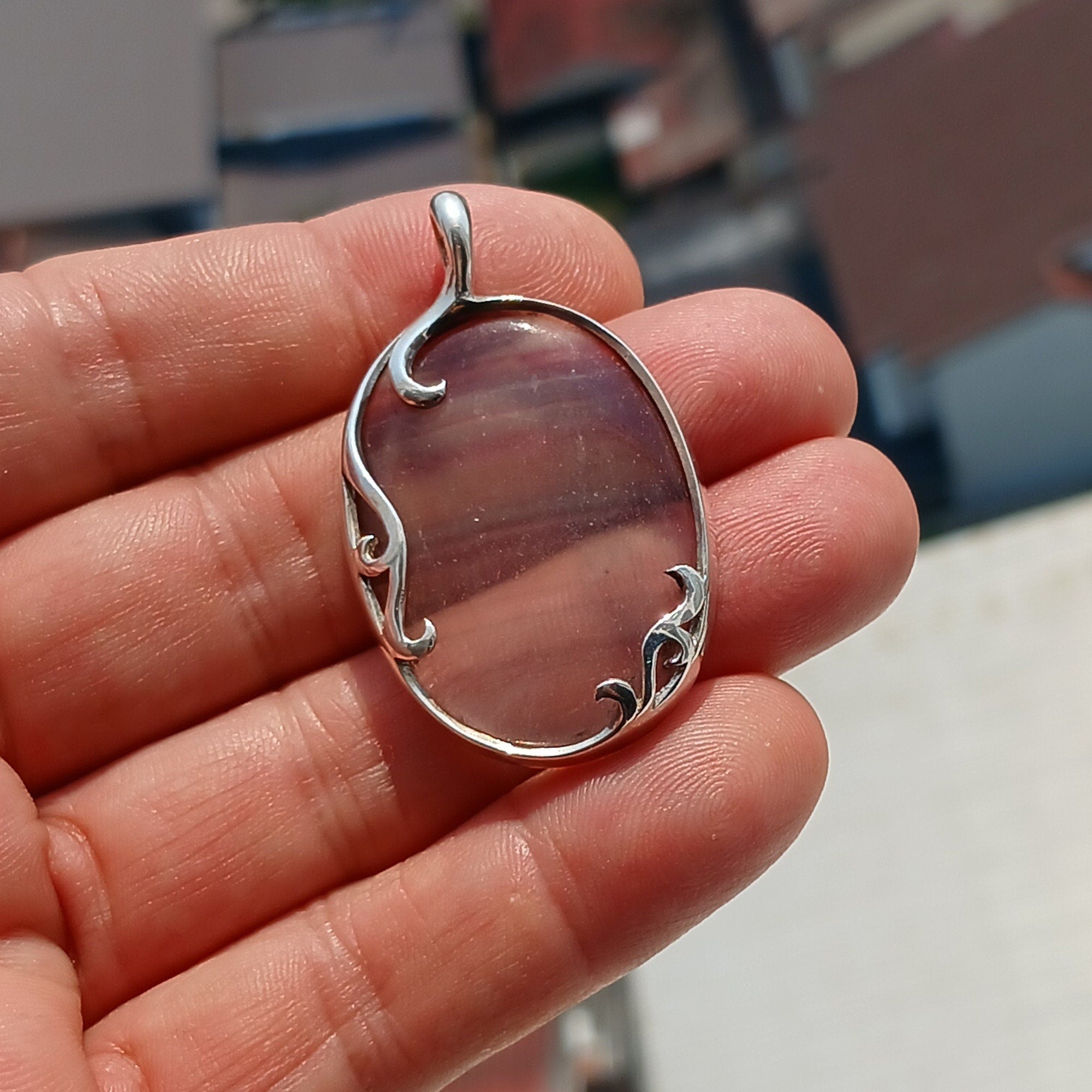 Oval shaped sterling silver pendant featuring a multicolor fluorite gemstone, elegantly designed with a pear cut.