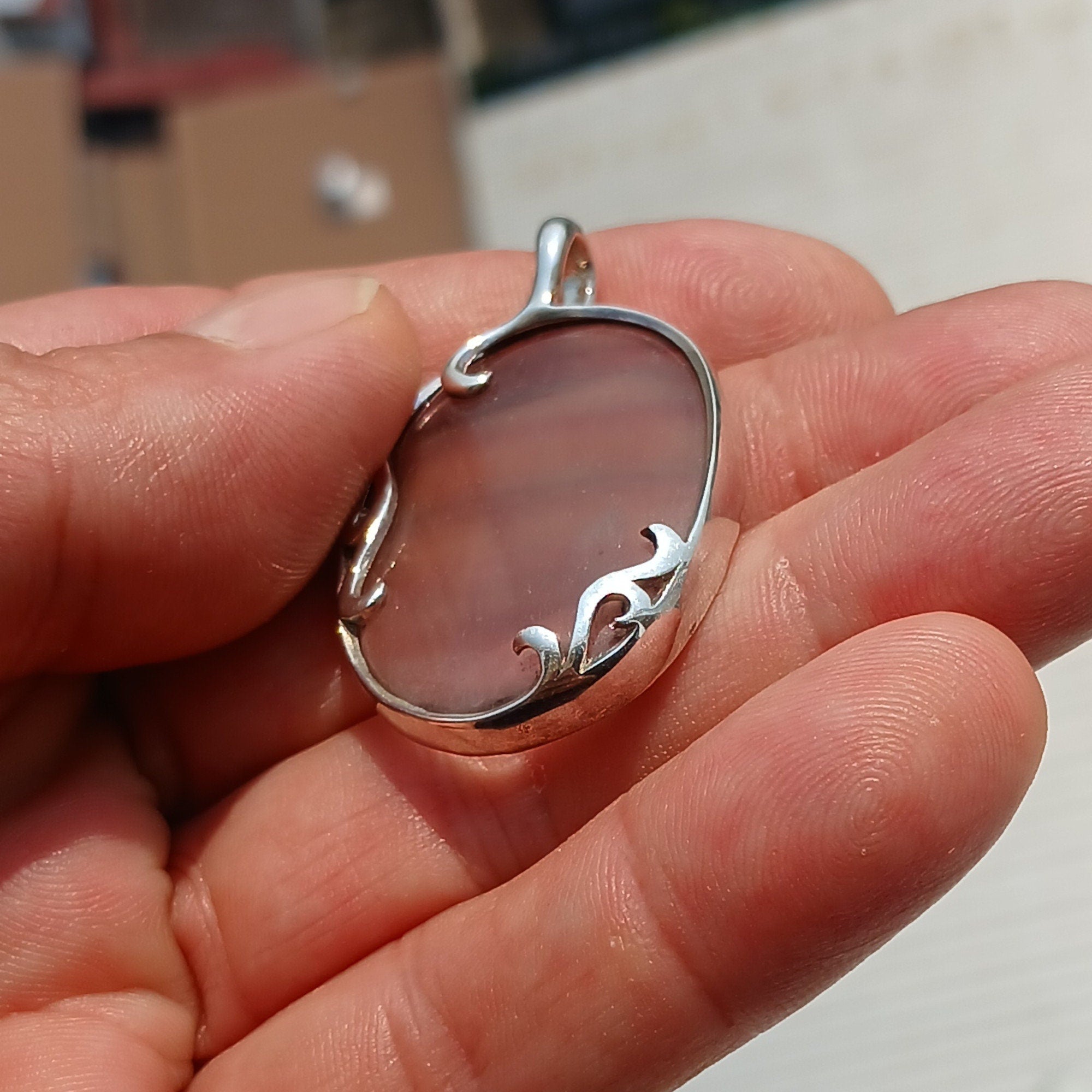 Oval shaped sterling silver pendant featuring a multicolor fluorite gemstone, elegantly designed with a pear cut.