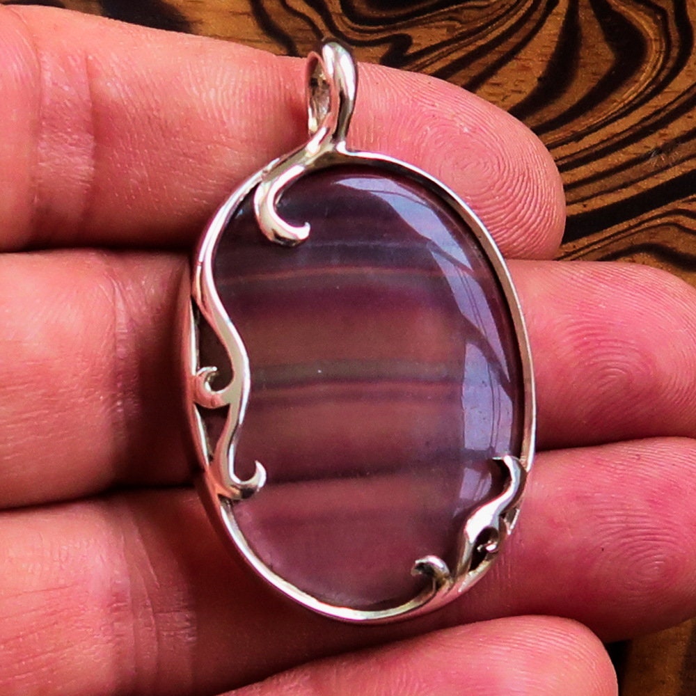 Oval shaped sterling silver pendant featuring a multicolor fluorite gemstone, elegantly designed with a pear cut.