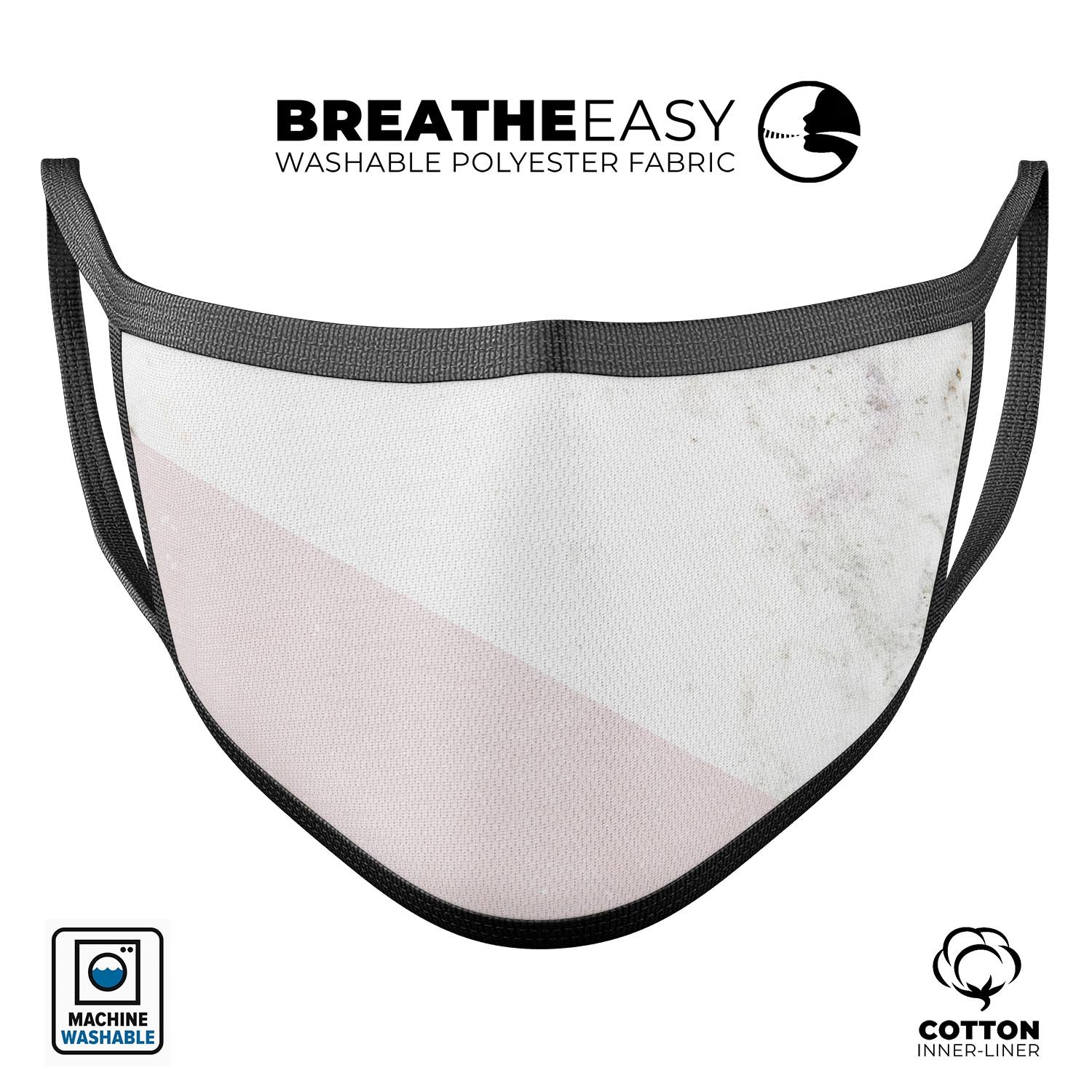 Pale pink slanted marble surface reusable face mask, showcasing adjustable ear loops and soft cotton interior.