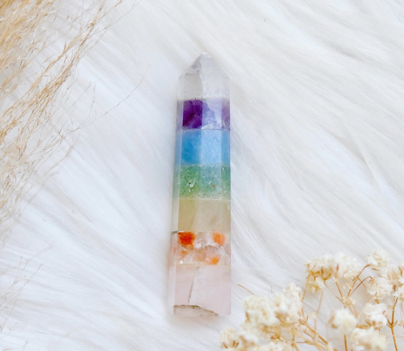 A beautiful Pastel Rainbow Chakra Wand featuring seven distinct crystals, perfect for energy work and chakra balancing.