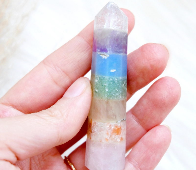 A beautiful Pastel Rainbow Chakra Wand featuring seven distinct crystals, perfect for energy work and chakra balancing.