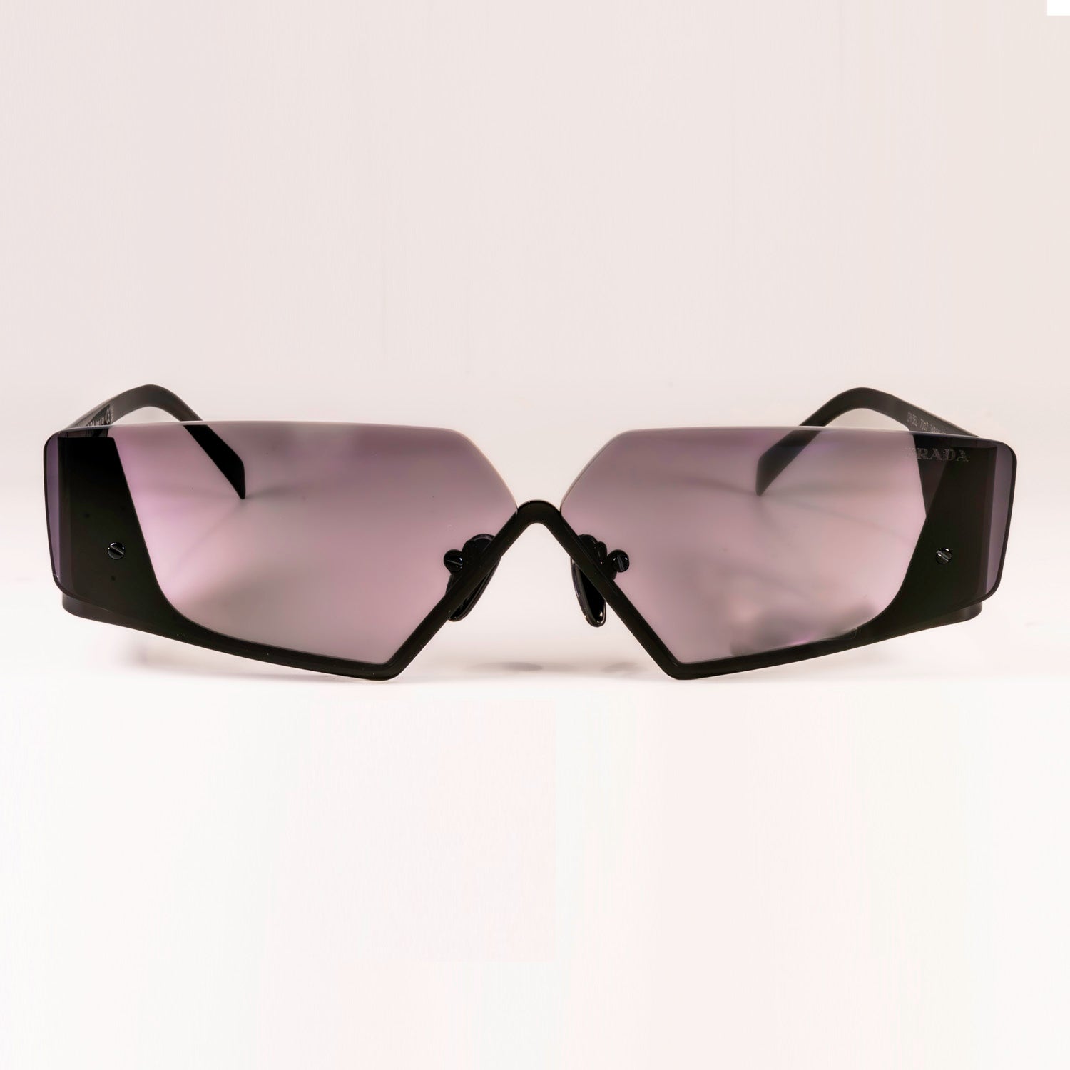 Prada PR 58ZS - 1AB06L Sunglasses featuring a black metal frame and dark grey lenses, showcasing an irregular shape for a modern look.