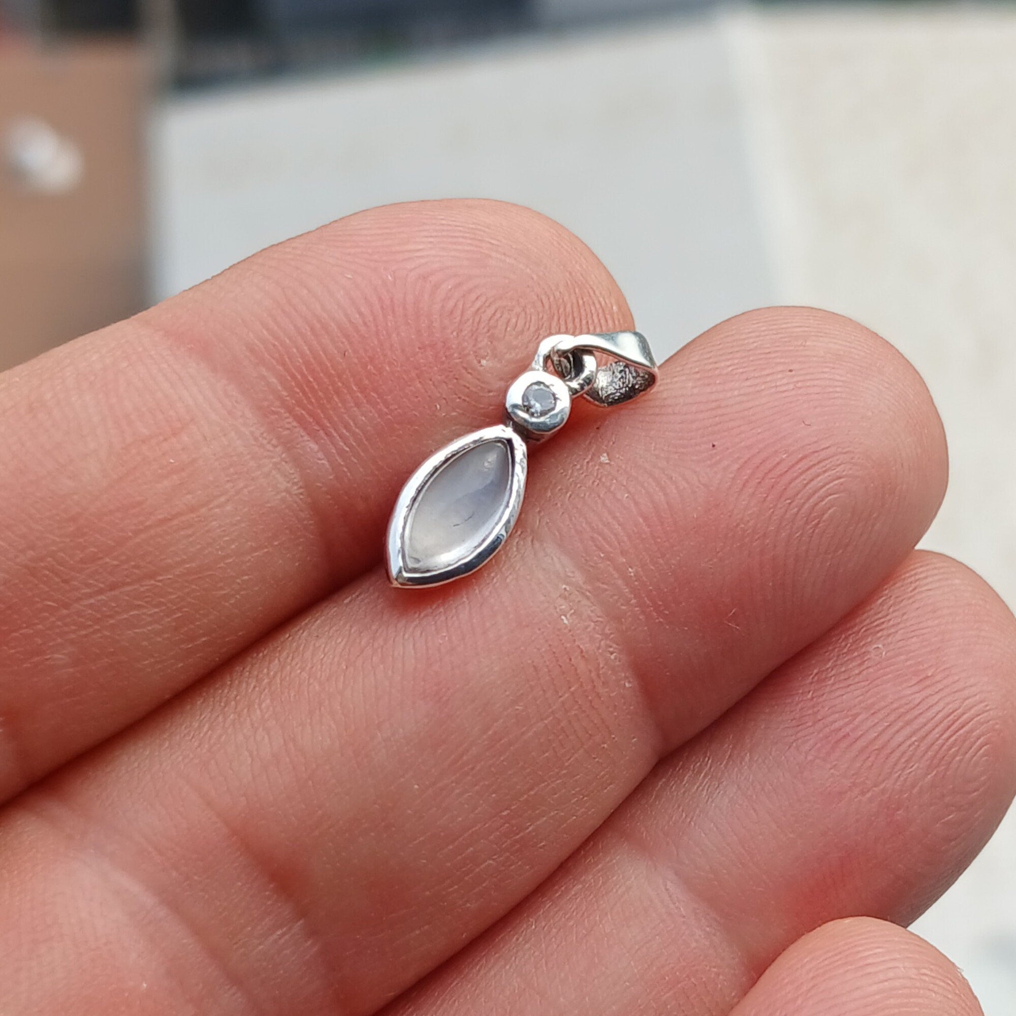 Elegant sterling silver moonstone pendant with cubic zirconia accents, showcasing a beautiful moonstone centerpiece.