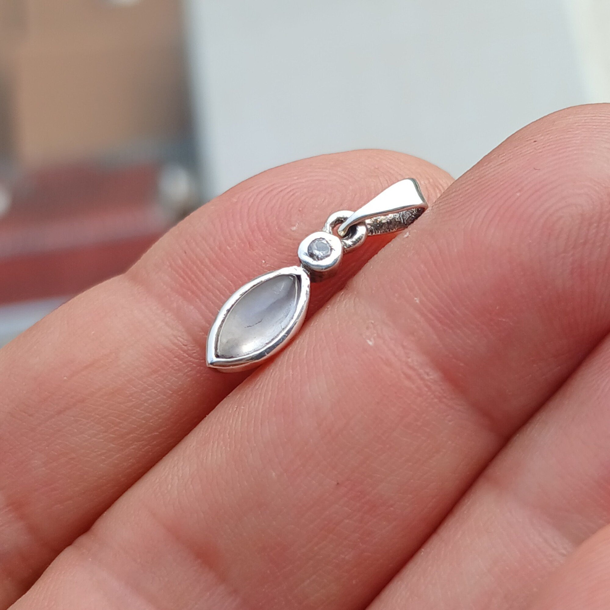 Elegant sterling silver moonstone pendant with cubic zirconia accents, showcasing a beautiful moonstone centerpiece.