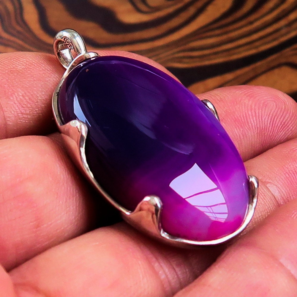 A beautiful Purple Agate Pendant set in sterling silver, showcasing a vibrant purple cabochon with intricate patterns.