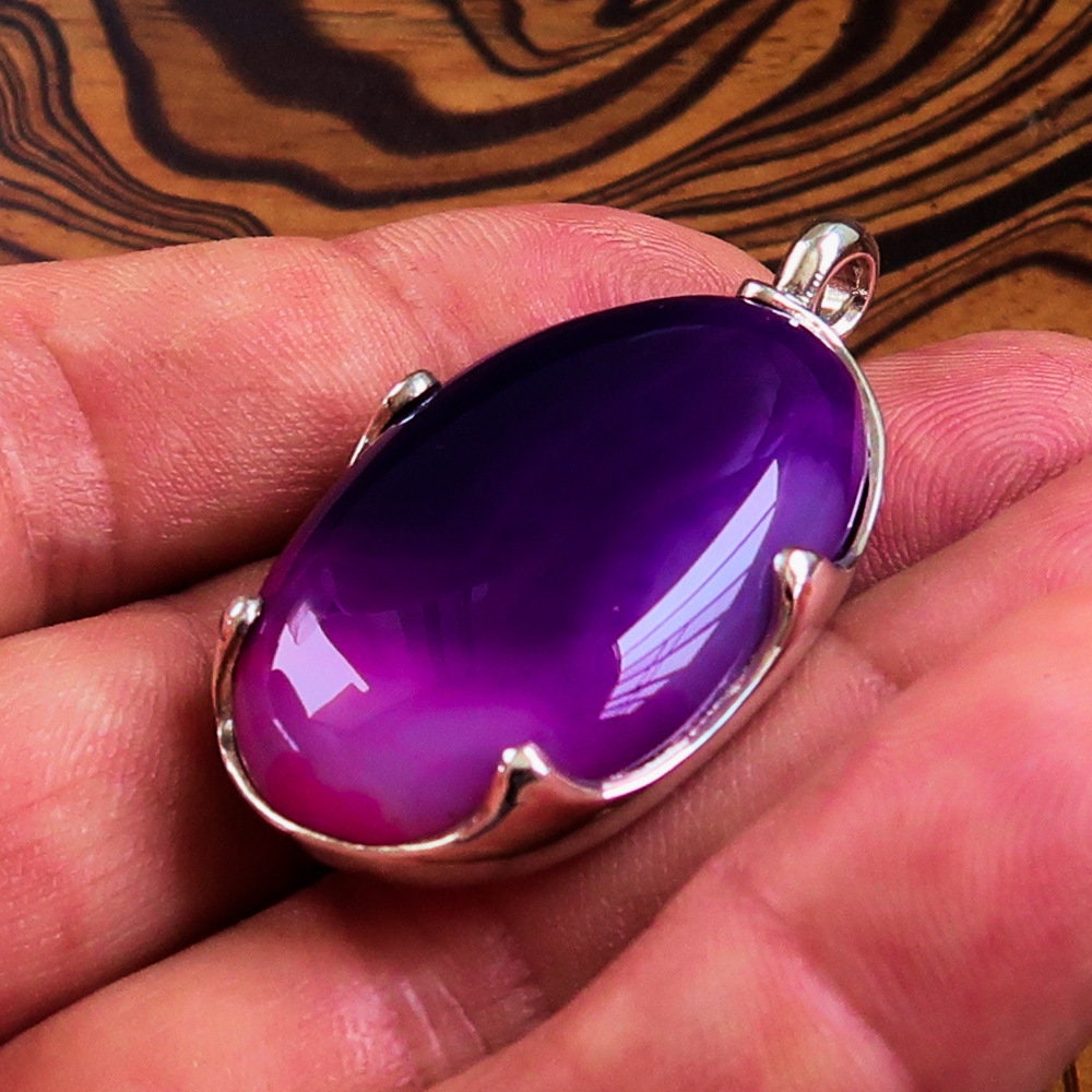 A beautiful Purple Agate Pendant set in sterling silver, showcasing a vibrant purple cabochon with intricate patterns.