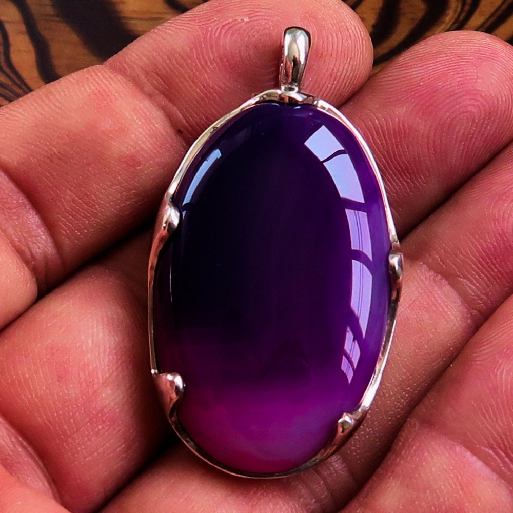 A beautiful Purple Agate Pendant set in sterling silver, showcasing a vibrant purple cabochon with intricate patterns.