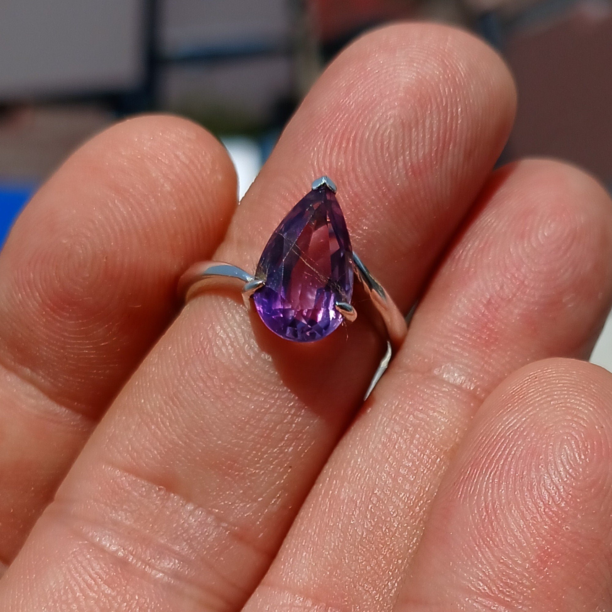 A beautiful purple amethyst ring in sterling silver, featuring a pear-shaped gemstone with a polished finish, showcasing elegance and style.