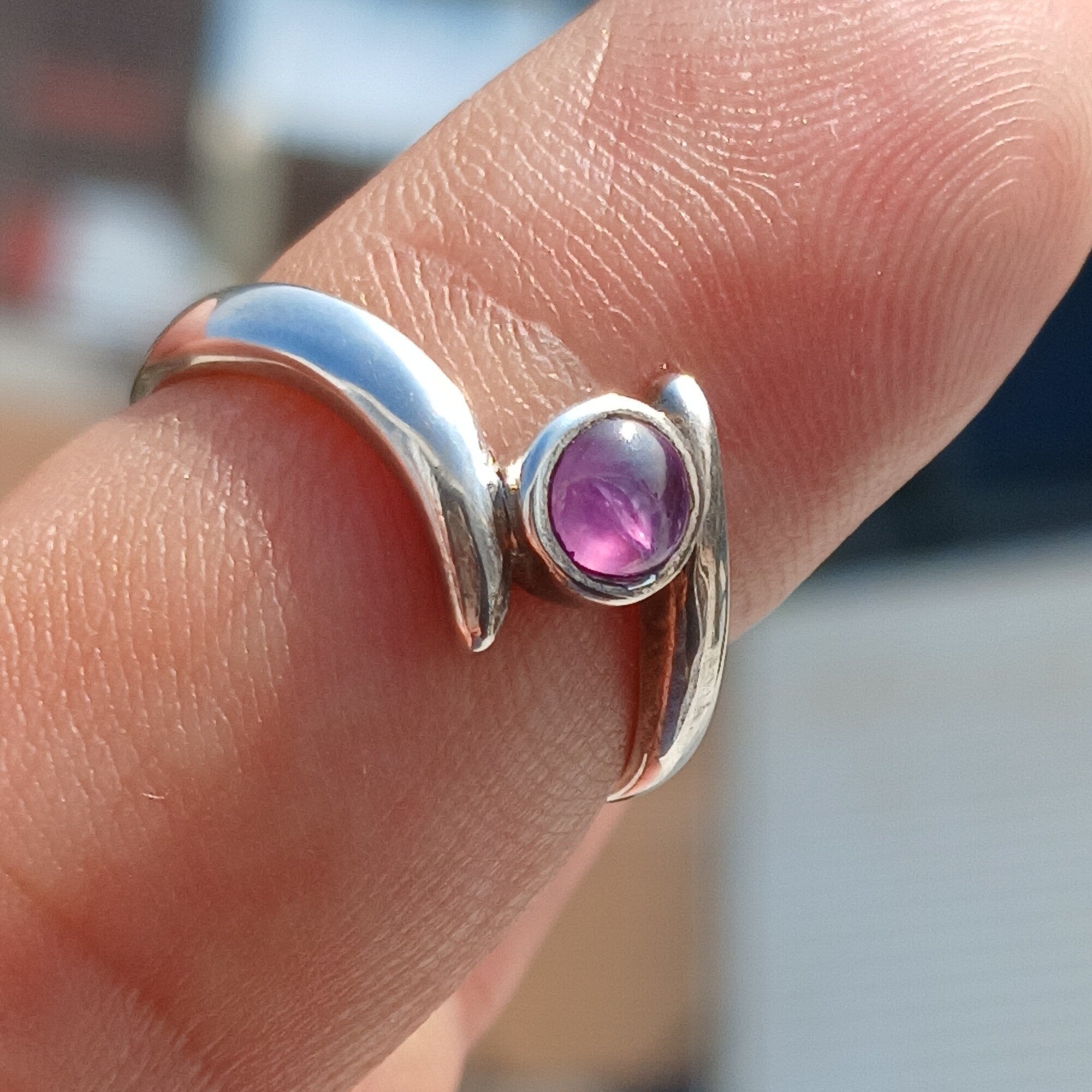 A beautiful purple star sapphire ring set in polished sterling silver, showcasing a unique star effect.