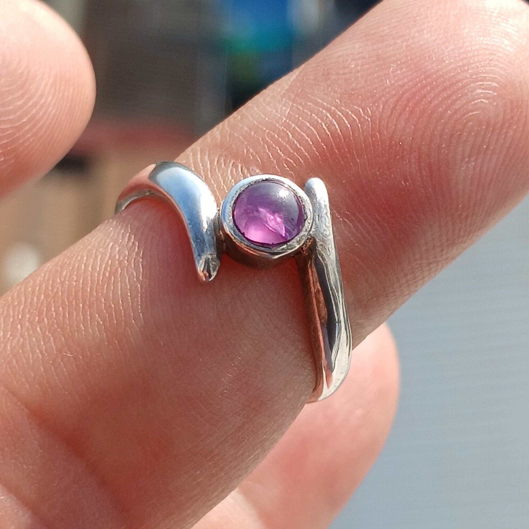 A beautiful purple star sapphire ring set in polished sterling silver, showcasing a unique star effect.