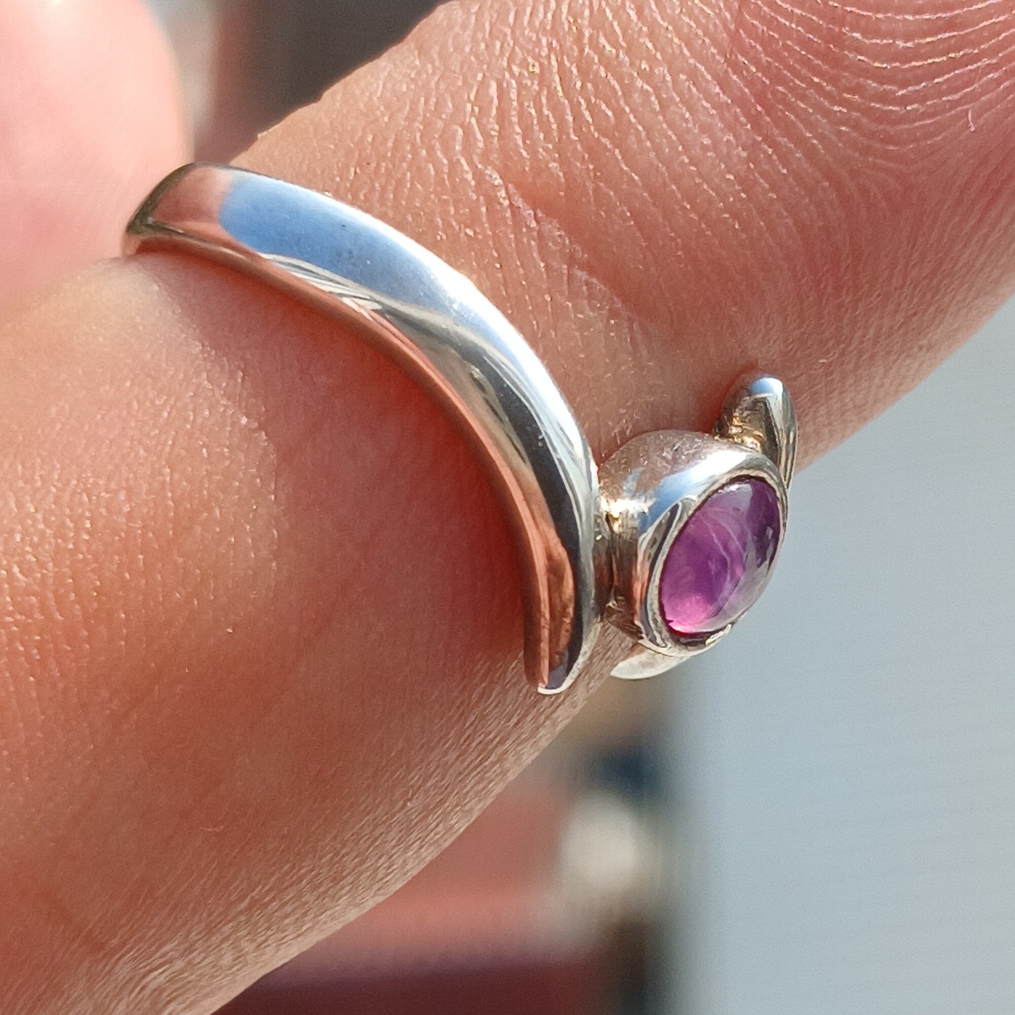 A beautiful purple star sapphire ring set in polished sterling silver, showcasing a unique star effect.