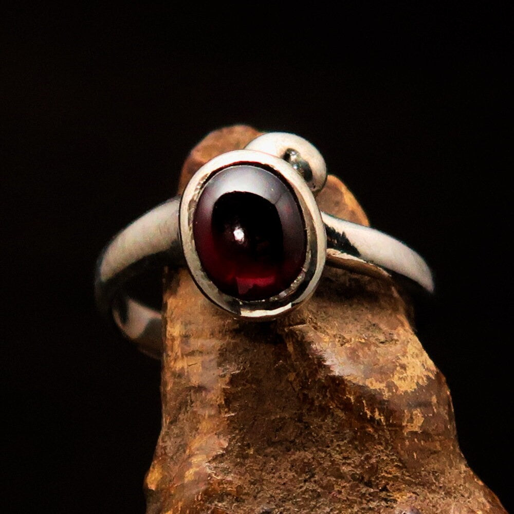 Handmade Red Garnet Ring in sterling silver with an oval-shaped garnet cabochon, showcasing a polished finish.