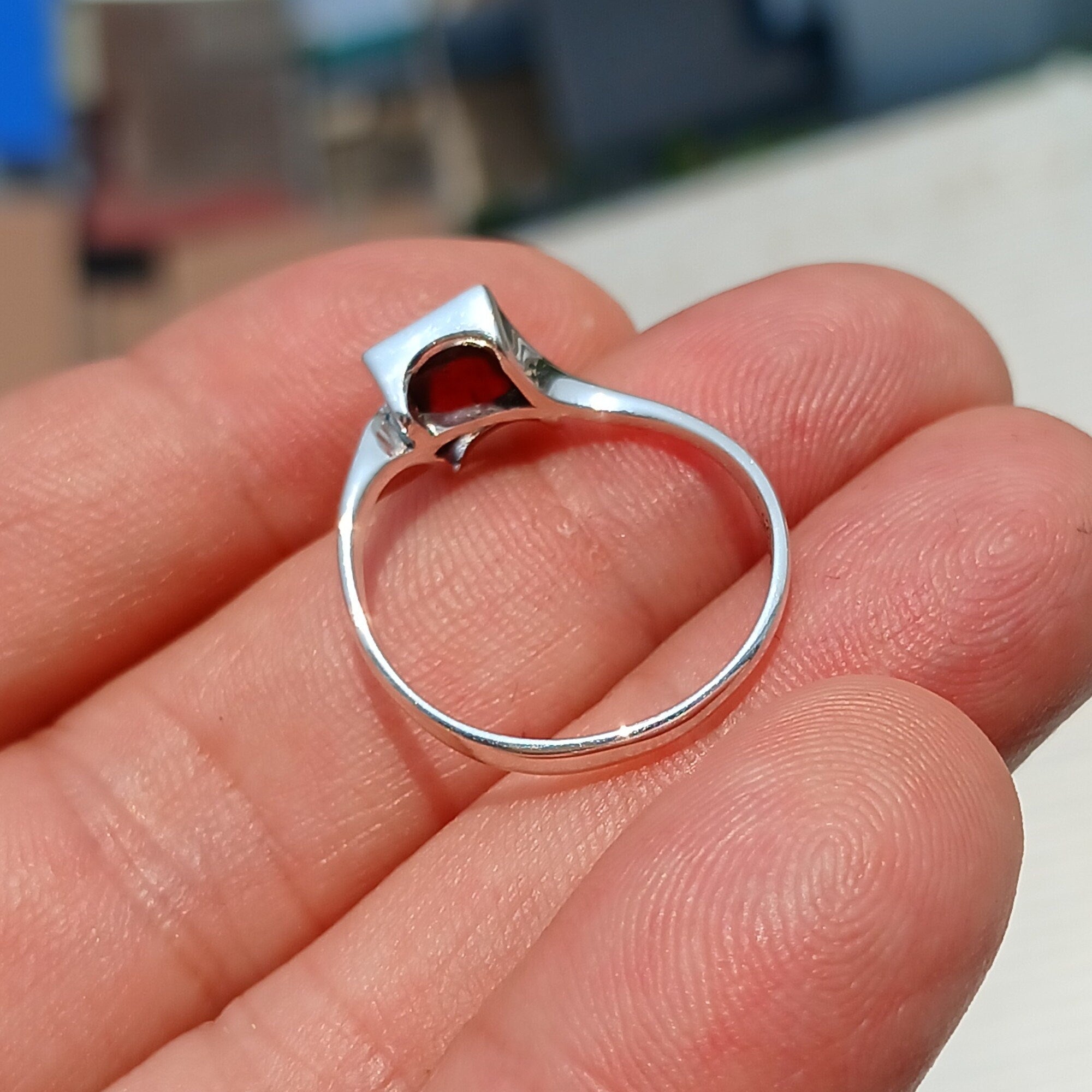 A beautiful Red Garnet Ring featuring a rectangle-shaped cabochon set in a polished sterling silver band, showcasing its vibrant red color.